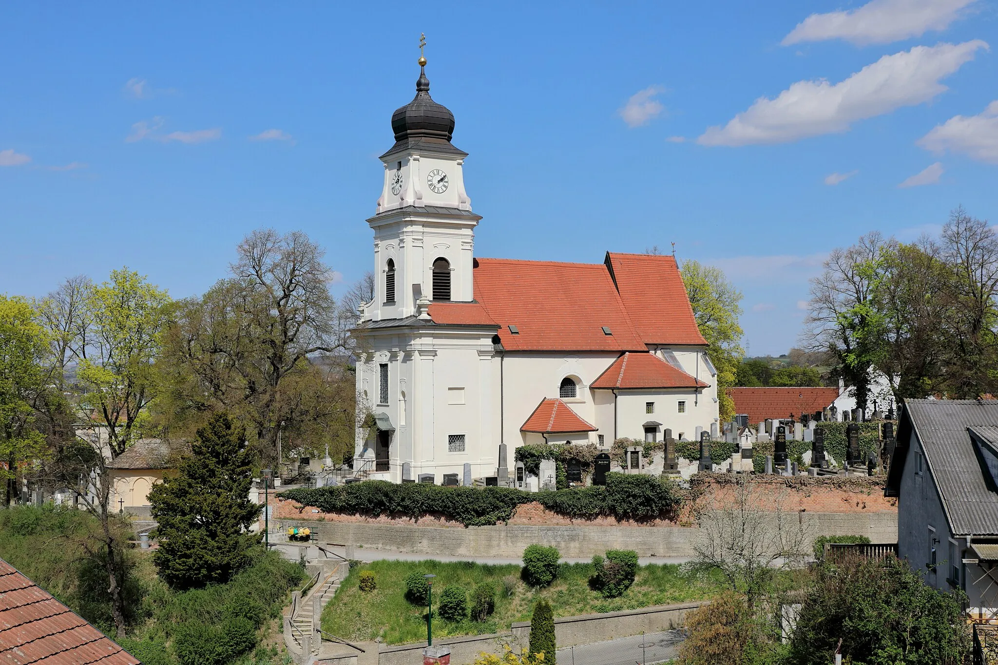 Photo showing: Südwestansicht der röm.-kath. Pfarrkirche hl. Johannes der Täufer in der niederösterreichischen Marktgemeinde Bisamberg. Die Kirche steht erhöht über dem Ort am nordwestlichen Abhang des Bisamberges und ist von einem Friedhof umgeben. Sie ist eine im Kern romanische, barockisierte Saalkirche mit spätgotischem Chor und spätbarockem Westturm. Der tiefe Fassadenvorbau mit Turm wurde von 1720 bis 1735 errichtet.