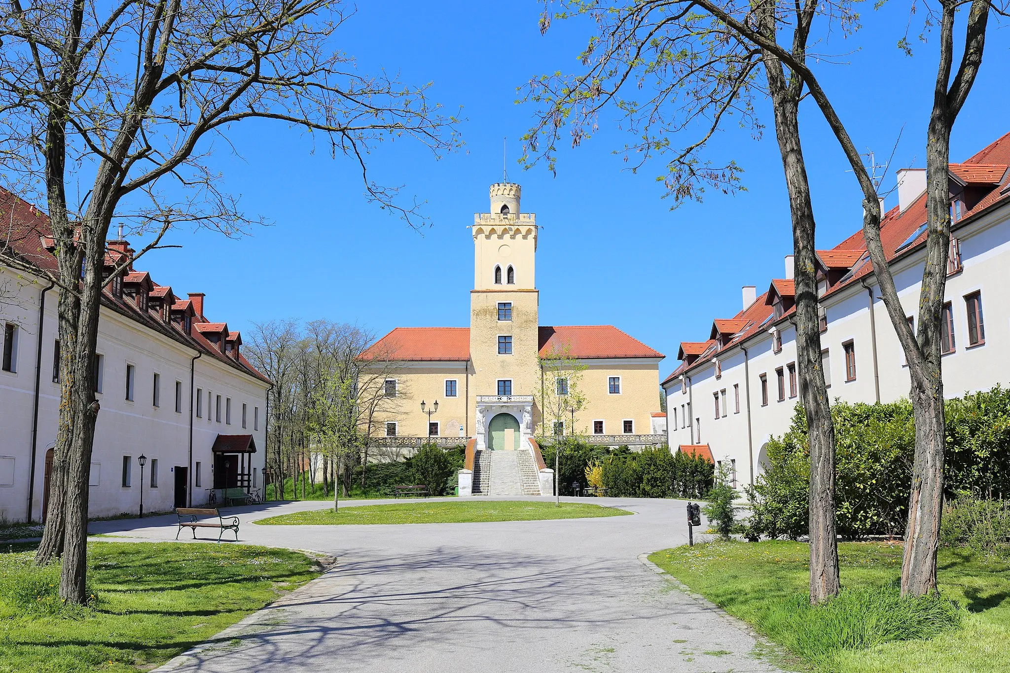 Photo showing: Südostansicht des Schlosses in Dürnkrut mit dem ehemaligen Meierhof im Vordergrund. Das vierflügige Wasserschloss wurde nach schweren Kriegsschäden in der ersten Hälfte des 16. Jahrhunderts weitgehendst neu errichtet. Der zweigeschossige Renaissancebau um einen quadratischen Hof ist teilweise von einem Wassergraben umgeben. Nachdem das Schloss 1830 in den Besitz der Familie Sachsen-Coburg-Gotha kam, erfolgte eine Neugestaltung des Torturmes; unter anderem mit der romantischen Zinnenbekrönung. Links im Bild der ehemalige Südflügel des Meierhofes. Er hat eine Kernsubstanz aus dem Anfang des 17. Jahrhunderts und wurde mehrfach verändert. Rechts im Bild ein Neubau, der im Erscheinungsbild dem ehemaligen Nordflügel des Meierhofes nachempfunden wurde.