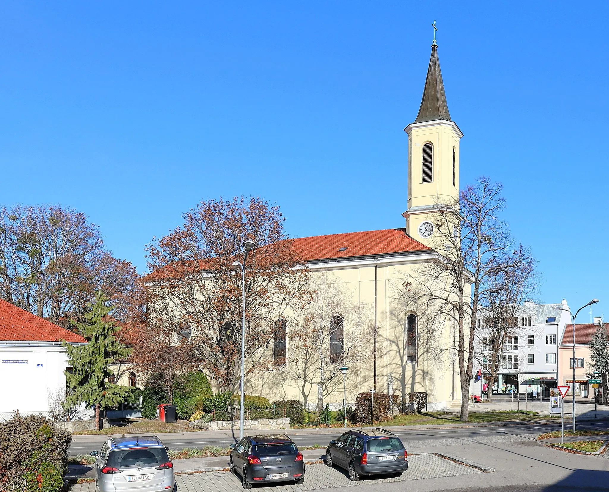 Photo showing: Zentrum der niederösterreichischen Gemeinde Ebergassing mit der röm.-kath. Pfarrkirche Maria Himmelfahrt und davor ein barocker Gnadenstuhl-Figurenbildstock. Die Saalkirche mit zweigeschossigem Fassadenturm und einem quadratischen Chorschluss wurde ab 1851 errichtet und am 25. September 1853 geweiht.