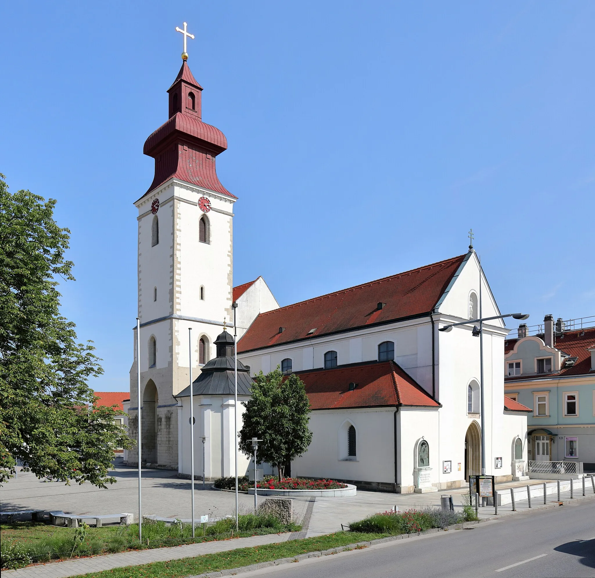 Photo showing: Nordwestansicht der röm.-kath. Pfarrkirche Maria Schutz in der niederösterreichischen Stadtgemeinde Groß-Enzersdorf. Eine ehemalige Wehrkirche mit wuchtigem Nordturm, die in der 2. Hälfte des 17. Jahrhunderts brockisiert wurde. Das Langhaus wurde Ende des 13. Jahrhunderts errichtet und der erhöhte Chor Ende des 14. Jahrhunderts. Die Sakristei und der Kapellenanbau wurden in der Barockzeit errichtet.