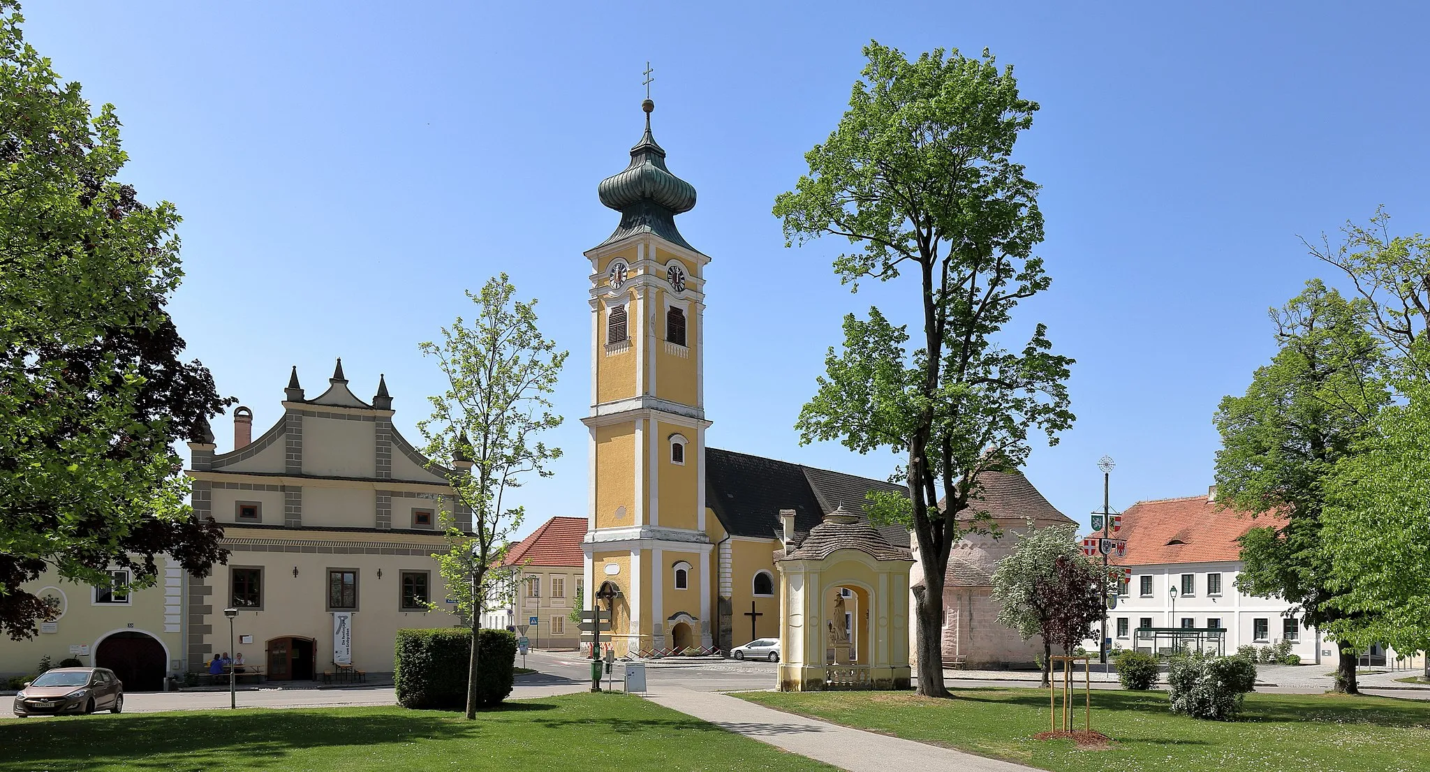 Photo showing: Der Hauptplatz von Hadersdorf am Kamp in der niederösterreichischen Marktgemeinde Hadersdorf-Kammern. In der Bildmitte die kath. Pfarrkirche hll. Peter und Paul, davor die Nepomukkapelle, rechts der Karner und links der Kirche das Rathaus bzw. Gemeindeamt. Alle angeführten Objekte sind denkmalgeschützt.