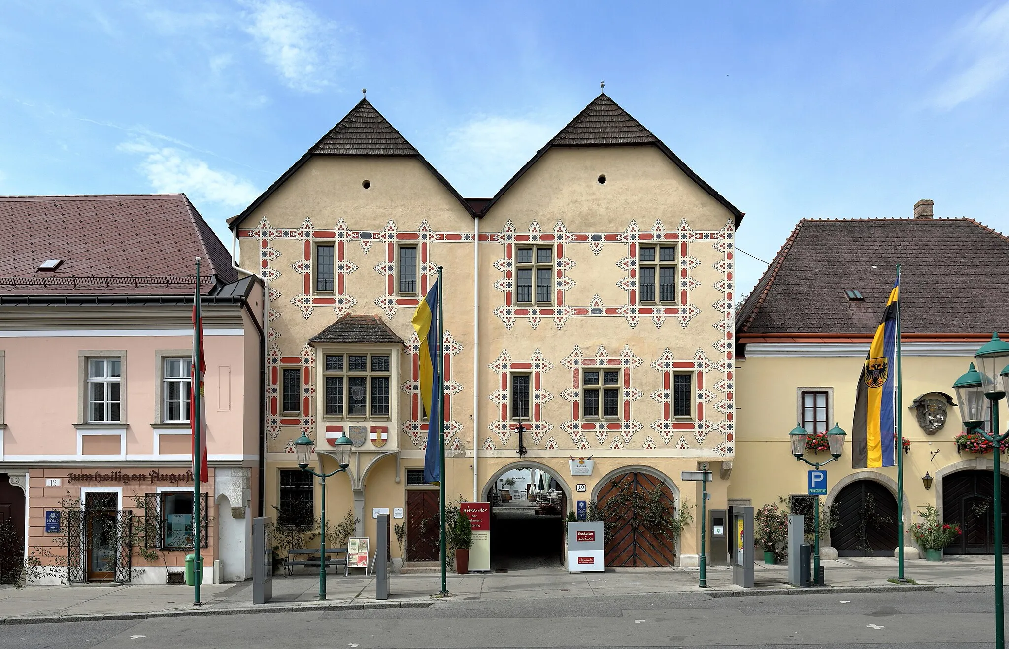 Photo showing: Das Rathaus am Marktplatz Nr. 10 in der niederösterreichischen Marktgemeinde Perchtoldsdorf. Der dreigeschossige Bau mit Doppelgiebelfassade und langgestreckten Hofflügeln wurde Mitte des 15. Jahrhunderts als Bürgerhaus errichtet und 1554 als Rathaus in Verwendung genommen. Die mit Seccomalerei (rekonstruiert) geschmückte Fassade stammt aus dem Jahr 1526. Es ist neben dem Wagnerhaus (Marktplatz 23) das einzige Haus im Ort, das auch äußerlich seinen gotischen - in diesem Fall spätgotischen - Charakter bewahrt hat.