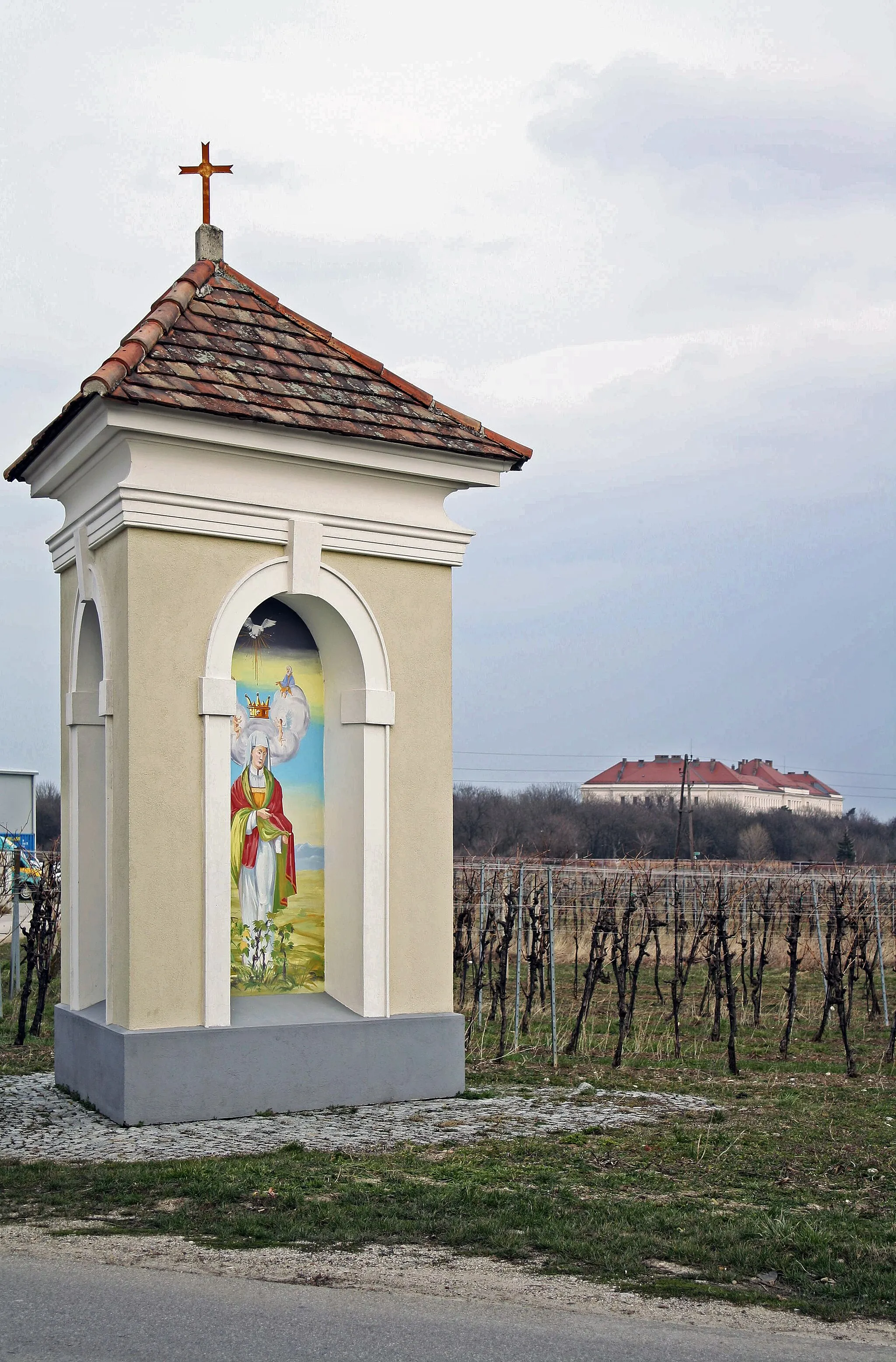 Photo showing: de:Niederösterreich: dreiseitiger de:Bildstock (Ursprung: 18. Jahrhundert; Wiedererrichtung: 1984) an der Gemeindegrenze von de:Traiskirchen (de:Katastralgemeinde de:Tribuswinkel) zu de:Pfaffstätten. (Im Hintergrund: de:Flüchtlingslager Traiskirchen).