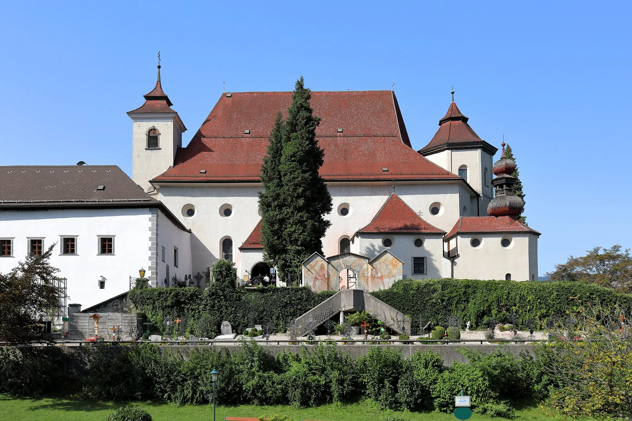 Photo showing: Südansicht der röm.-kath. Pfarrkirche Mariä Krönung in der oberösterreichischen Gemeinde Traunkirchen und davor der auf zwei Trassenebenen angelegte Friedhof. Ursprünglich als dreischiffige Klosterkirche ab 1632 errichtet und 1652 geweiht, nachdem die Vorgängerkirche in der Nacht vor dem 10. Jänner 1632 abbrannte. Nach der Aufhebung des Ordens 1773 wurde das barocke Bauwerk 1778 zur Pfarrkirche. 1804 trug man großteils den Turm ostseitig über dem Hochaltar ab und errichtete einen niederen Turm an der Westseite der Kirche.