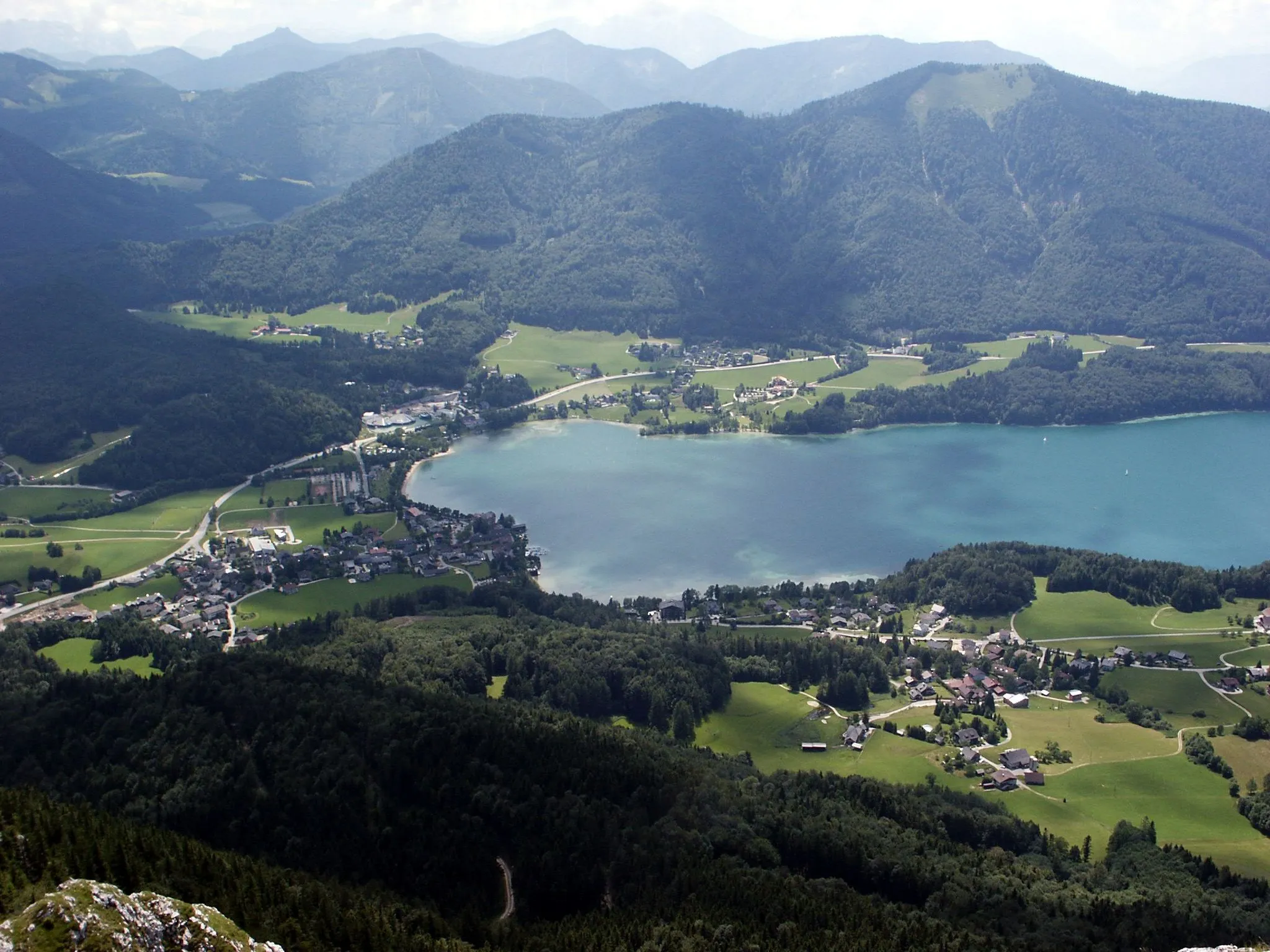 Photo showing: The village "Fuschl am See" in Salzburg/Austria and the lake Fuschlsee as seen from the mountain Schober (Frauenkopf). Besides the main road you can also see the new headquater of Red Bull which looks like two cones, the old HQ beside it is too small to recognize.
The upper right mountain is the Fibling, 1307 meters
Picture taken 2006-07-03 by myself D.Höss./Birka

licence: GFDL fo shizzle