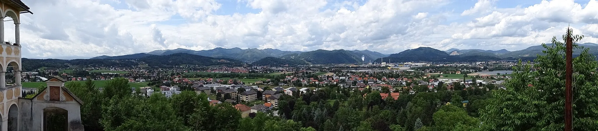 Photo showing: Blick von der Wallfahrtskirche Maria Straßengel auf die Ortsteile Judendorf-Straßengel und Gratwein der Gemeinde Gratwein-Straßengel. In der Mitte rechts erkennt man die Pfarrkirche Gratwein und die rauchenden Schornsteine gehören zur Papierfabrik SAPPI, welche bereits auf dem Gemeindegebiet von Gratkorn liegt. Der Ortsteil Eisbach befindet sich hinter den Hügeln im Vordergrund.