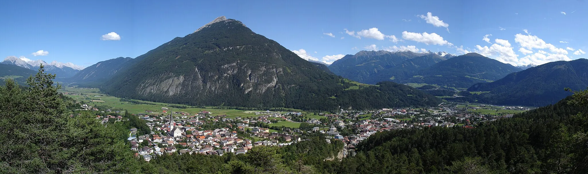 Photo showing: Imst vom 'Wetterkreuz' aus gesehen, Blickrichtung Ost. Ganz links sind die Mieminger Berge zu sehen (Wannig, Handschuhspitzen, Marienberg, Vorderer Drachenkopf, Grünstein, Griesspitzen, Mitterspitzen, Hochplattig). Links der Bildmitte erhebt sich der Tschirgant. Rechts davon die nördlichen Ausläufer der Stubaier und Ötztaler Alpen.