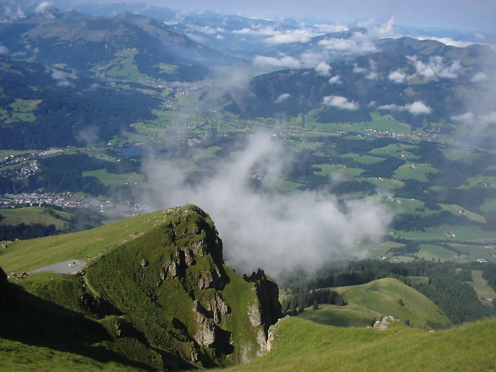 Photo showing: View from the top of the Kitzbüheler Horn mountain, looking down toward the town of Kitzbühel, in the far left of the picture, and lake Schwarzsee middle left.