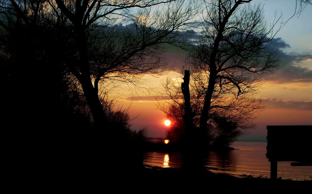 Photo showing: Dieses Bild wurde von mir persönlich bei der Höchster Bodenseebucht in der Nähe des Gasthauses "Glashaus" aufgenommen. Es zeigt den April-Sonnenuntergang in Blickrichtung Gaißau und Höchster Hafen. Die rote Farbe des Himmels ist typisch für diese Jahres- und Uhrzeit im Rheindelta Naturschutzgebiet Ramsar (größtes am Bodensee).