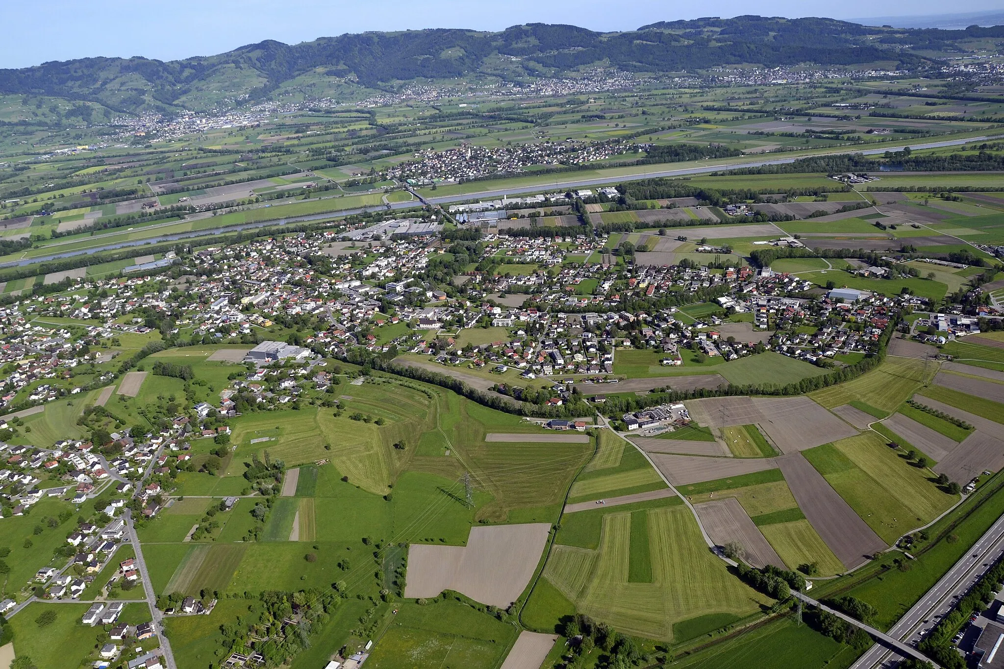 Photo showing: Luftbild der österreichischen Gemeinde Mäder von Osten aus gesehen (im Bildhintergrund der Alpenrhein und dahinter die Schweiz).