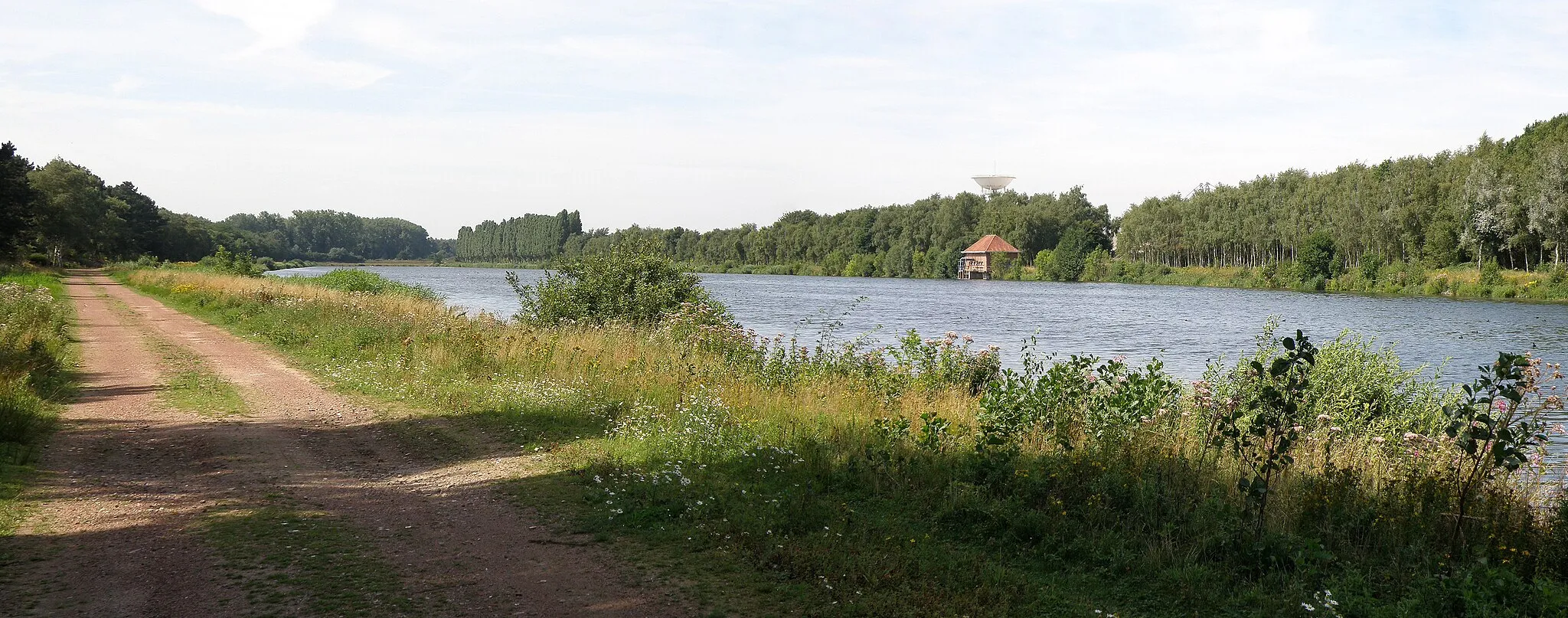 Photo showing: Duffel (prov. Antwerpen, België). Waterbekken aan de linkeroever van de Nete. De Nete loopt achter de bomen rechts, evenwijdig met het waterbekken. Blik richting westen.