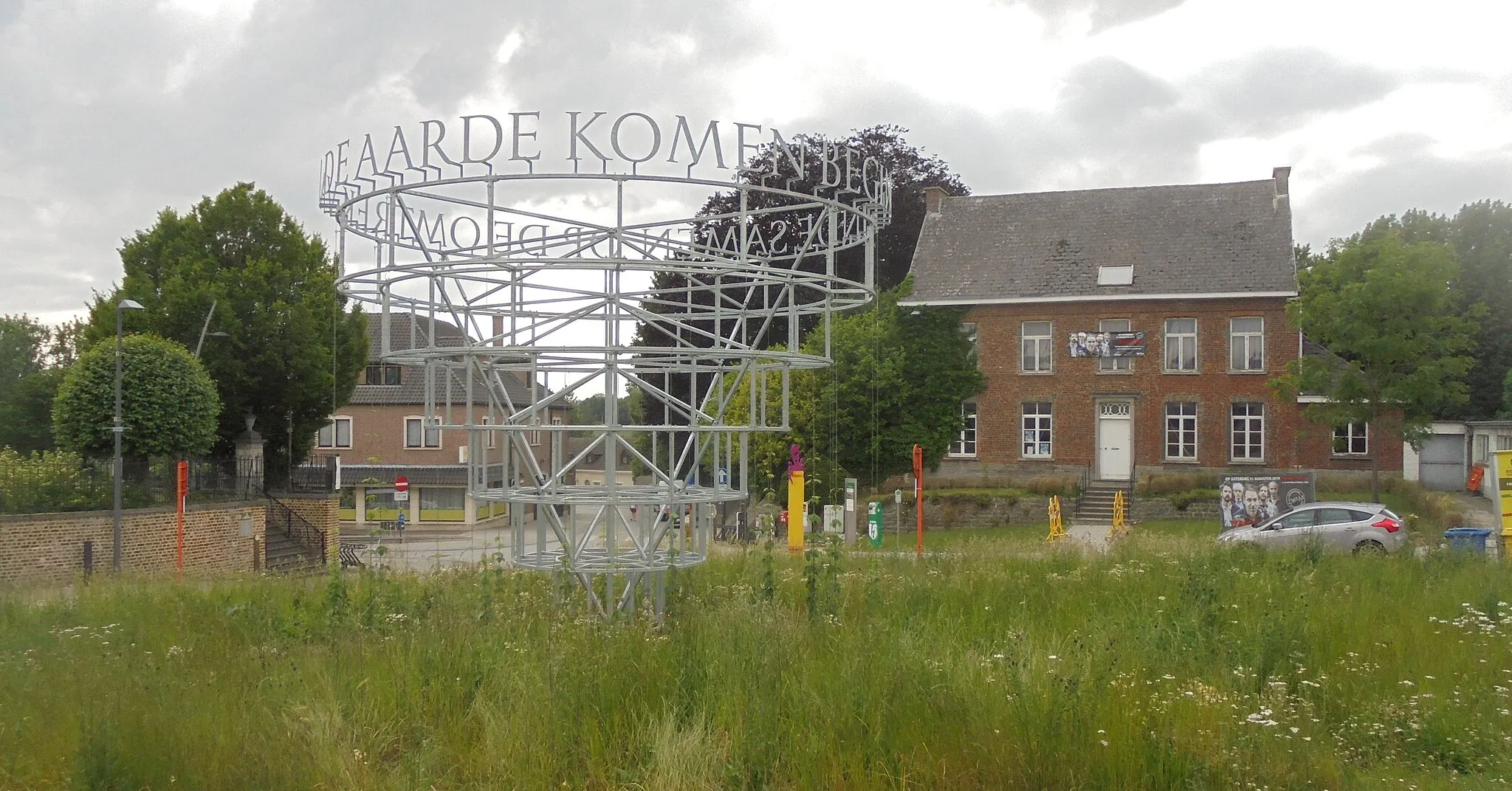 Photo showing: Monument met de tekst: op de omtrek van de aarde komen begin en einde samen - rechts de pastorie van de parochie - Meldert-dorp - Meldert - Aalst - Oost-Vlaanderen - België.
De Meldertenaren kozen voor het concept van beeldhouwer en kunstenaar Jean Bernard Koeman.