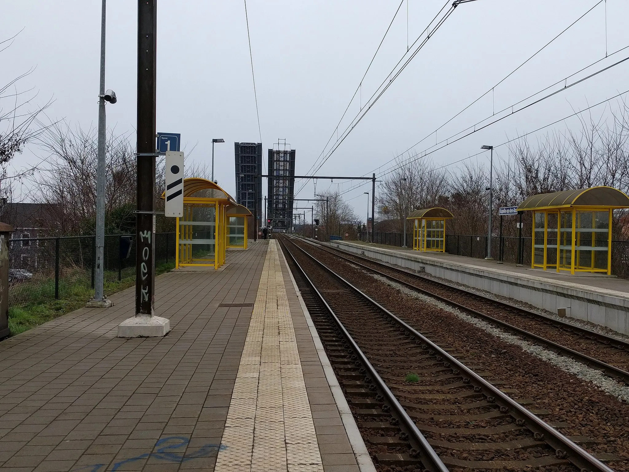 Photo showing: Het treinstation Kapelle-op-den-Bos met de brug over het kanaal omhoog (4 maart 2017).