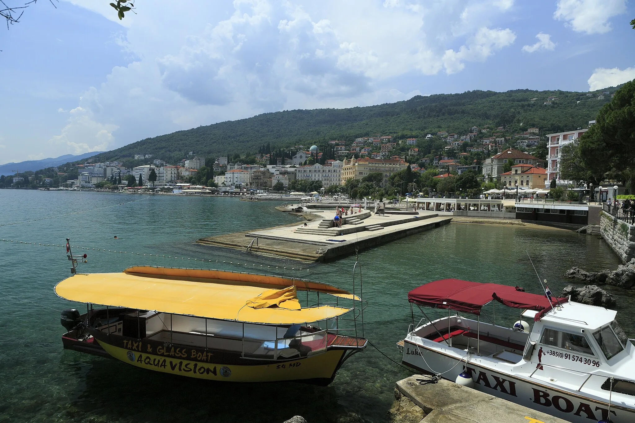 Photo showing: Ein kleines, aber gut geschütztes Hafenbecken vor dem St.-Jacobi-Park in Opatija. Davor liegen Taxiboote und gegenüber eine Badestelle.