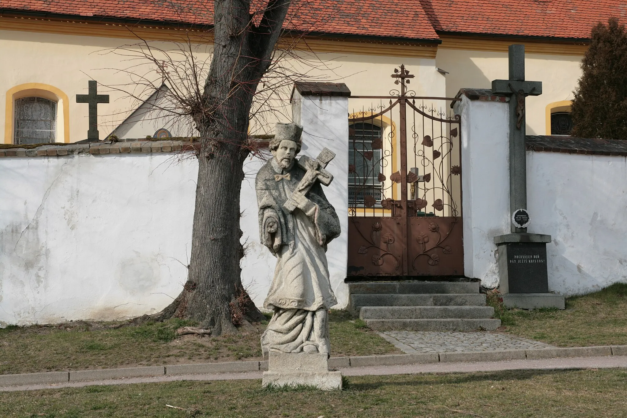 Photo showing: Městys Ledenice v okrese České Budějovice. Socha před kostelem sv. Vavřince a kříž u ohradní zdi kostela.