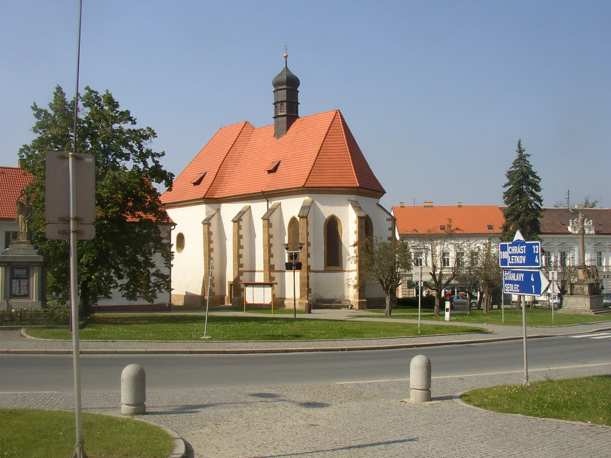 Photo showing: Church of Nativity of St John the Baptist in centre of Starý Plzenec, Plzeň-City District, Czech Republic. A view from the southeast, from town hall. The church of Romanesque origin from 11th century was later rebuilt in Gothic style. Marian Column from 1721 surrounded with statues of SS Joseph, Wenceslas, Ludmilla and Barbara can be seen on the right edge, WWI memorial on the left edge.