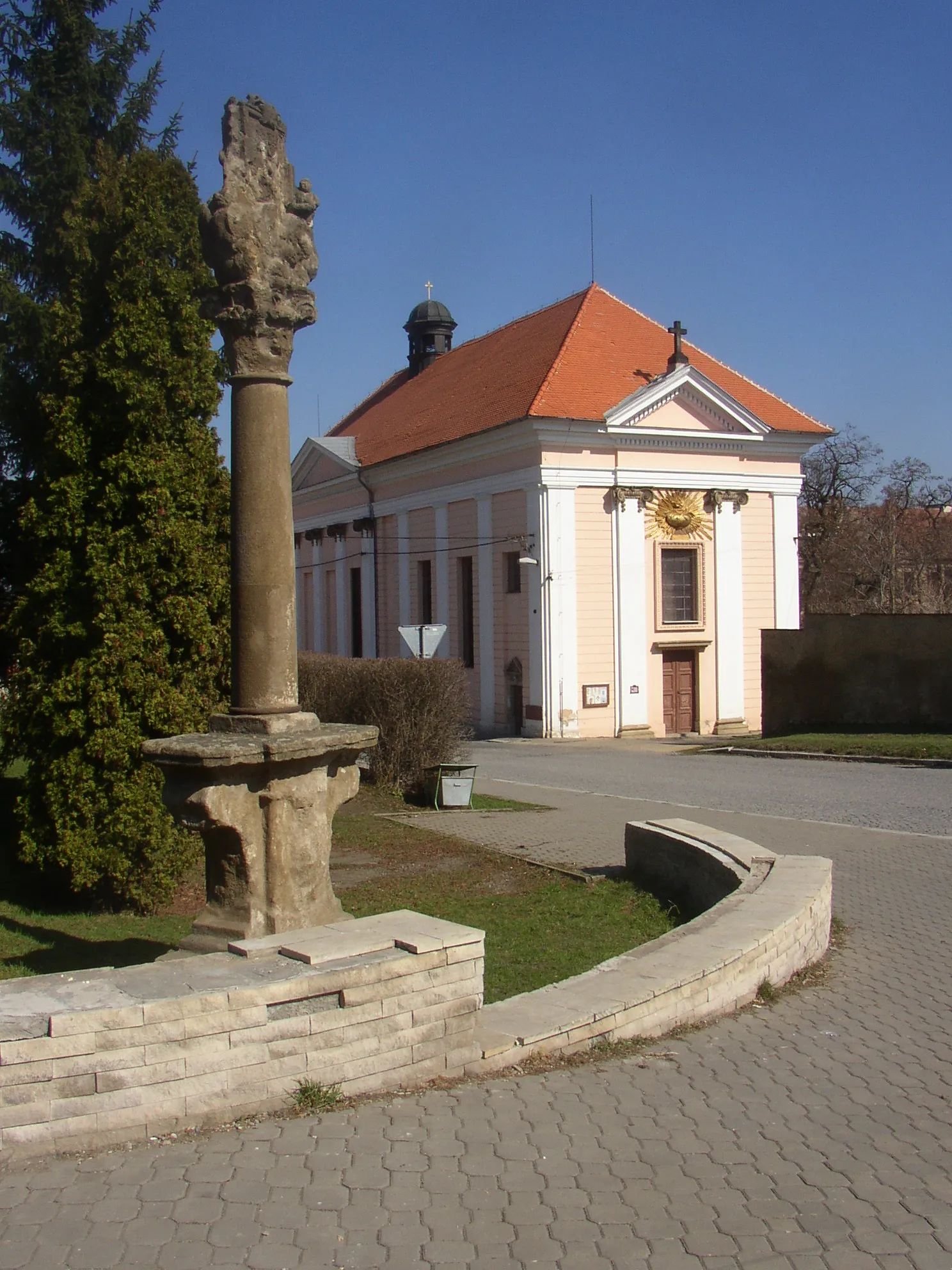 Photo showing: Church of Exaltation of the Holy Cross in Buštěhrad, Czech Republic. In the foreground an 18th century column with relief of Our Lady of Stará Boleslav.