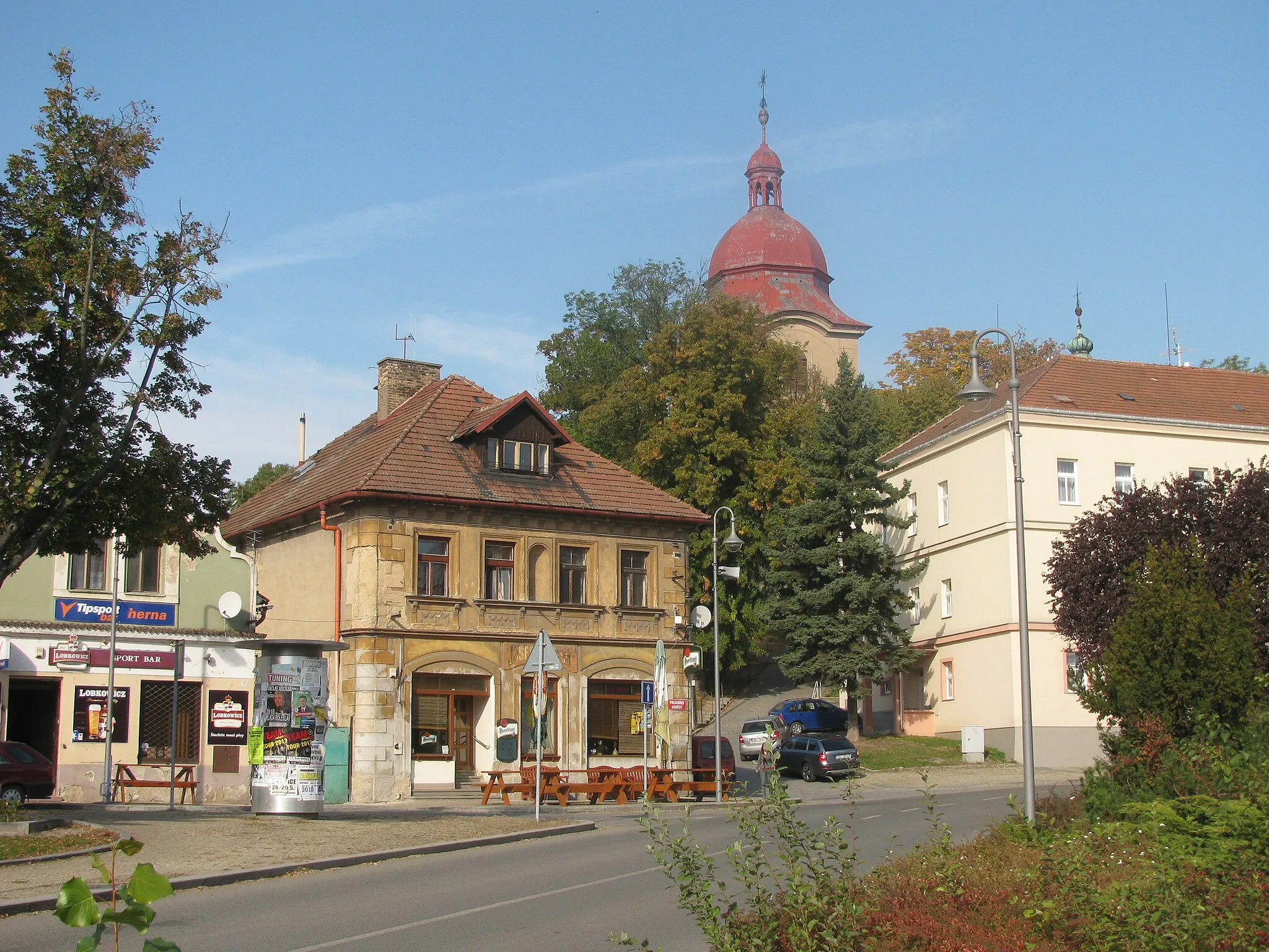 Photo showing: Část severní fronty domů Palackého nám. v Dobrovici, cesta ke kostelu sv. Bartoloměje, jeho věž v pozadí