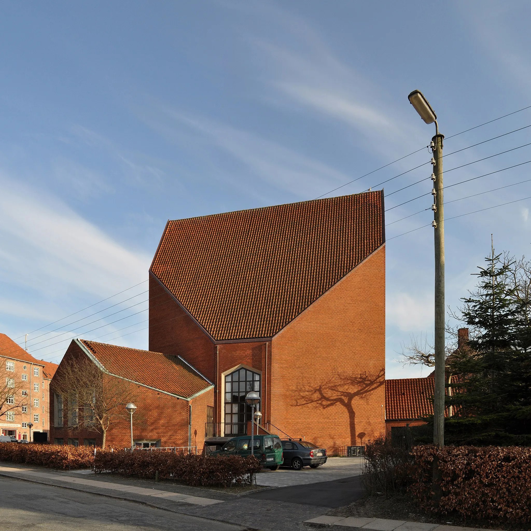 Photo showing: hyltebjerg kirke - church in vanløse, copenhagen 1944-1960.
architects: christian (1882-1968), erik (1909-1981) and aage holst (1915-2001).
what is a wartime church by holst and sons doing in a set about hans chr. hansen's architecture?  well, at the time any copenhagen architect could have told you.
in 1942, two years into the nazi occupation of denmark, hans chr. hansen and his partner viggo s. jørgensen finally won one of the many competitions they entered outside their work at the copenhagen municipality. It  was for a church in odense and not long after, the holsts won their first prize in vanløse with an almost exact copy of hansen and jørgensen’s project.
controversy ensued in the small world of Danish architects and steen eiler rasmussen was called upon to mediate between the two teams. oh, architects! I cringe at the thought. europe was on fire and in copenhagen, five men argued over intellectual property, not a proud moment for any of the involved. but hansen's church was never built and we are left with the copy when trying to understand this critical period in his development.
it was very much a project of the hour. massive unemployment and housing shortages led to new public works being undertaken despite the war. with a traumatized cultural life in copenhagen and no access to steel, architects collectively returned to p.v.jensen-klint’s brick nationalism in a movement kay fisker later named the klint school.
fisker had already reconciled the klint school with modernism in his seminal aarhus university from 1931, but the wartime projects looked back with greater determination to p.v.jensen-klint, and the churches discussed here are best described as fragments of jensen-klint’s ”krystalknude” or crystal-cluster of church towers, a sketch for a national memorial from 1907.
I have briefly discussed some of the consequences of abandoning modernism as it happened during the second world war in danish architecture, here and here. in hansen’s case, I believe it can be argued that he never entirely left the klint school once he had joined. brick gables and chimneys are found throughout his production, helping to tie his architecture in with the surrounding traditional buildings and perhaps with the expectations of its users too.
but on a more fundamental level, the demands of the klint school for exposed materials and honesty in construction would prepare him for the home he found in new brutalism, or rather made for himself since his first building in that style predates reyner banham’s 1955 manifesto by seven years. but we’ll get back to that in a project or two.
so, you ask, how did hostilities in copenhagen end? with a handshake in writing, a joint statement that no harm was done and none intended. a single line of text may reveal how steen eiler rasmussen managed that settlement: a mention of mogens koch's masterly 1941 brejning church, a building both the holsts and hansen/jørgensen were heavily indebted to.
a few years later, in 1948, hans christian hansen finally found himself as an architect.
the hans chr. hansen set.
more words, yada, yada, yada.
the comments I have added to some of my photos can be read together as a kind of mangled, yet surprisingly brief essay on hansen. repetitious and opinionated, it reflects the writer above his subject, but until someone does some serious research on hansen, a complete lack of competition makes me immune to criticism. enjoy :)
01. introduction, amager 1966.
02. the engineer as ideal, hansen's pre-war architecture, sundholm 1939.
03. the church he didn't build. war and the return to tradition, 1942-1944.
04. following fisker. wartime housing, hulgårds plads 1943.
05. the architect finding himself in kindergarten, skydebanen 1948.
06. developing the restless section. hanssted school 1954.
07. early industrial. nyborggade transformer 1958.
08. the brutalist, bellahøj 1961.
09. perfect self-confidence, ringbo nursing home 1961.
10. perfect idiosyncrasy. ringbo bell tower 1961.
11. the masterpiece, bremerholm 1962.
12. on the fine art of knowing when to be a backdrop. svanemølle 1966.
13. industrialized construction, a first response. svanemølle 1966.
14. concrete charm, bellahøj gas regulator 1967.
15. late irreverence. gasværksvejen school 1969.

all architecture photos with a CC license from this user can be used free of charge and in any way you see fit. 
if possible, please name photographer "SEIER+SEIER". if not, don't.
don't copy texts and comments. respect the few photos that are marked all rights reserved.

for internet use, common online courtesy says that you include a direct link back to the source of the photos, you use. and in the case of flickr photos, that the photo itself links straight back to the source.