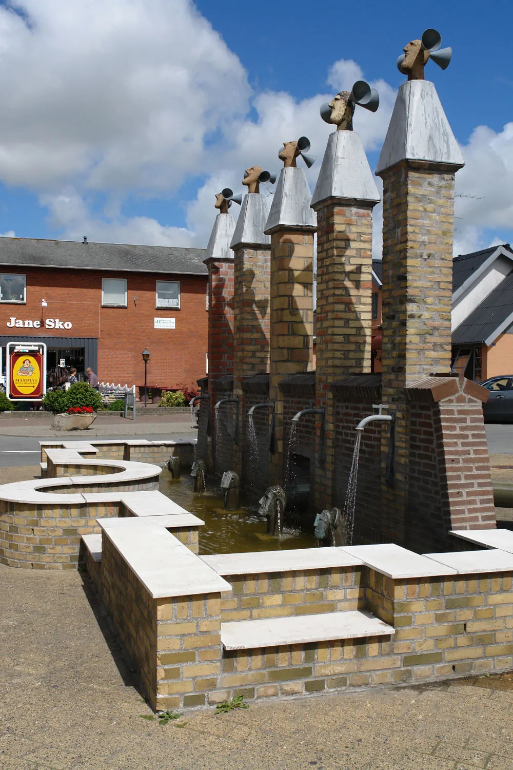 Photo showing: Springbrunnen in Sindal: „Die 5 Hermen“ (De 5 Hermer) von Niels Helledie. Standort: Marktplatz Nørre Torv