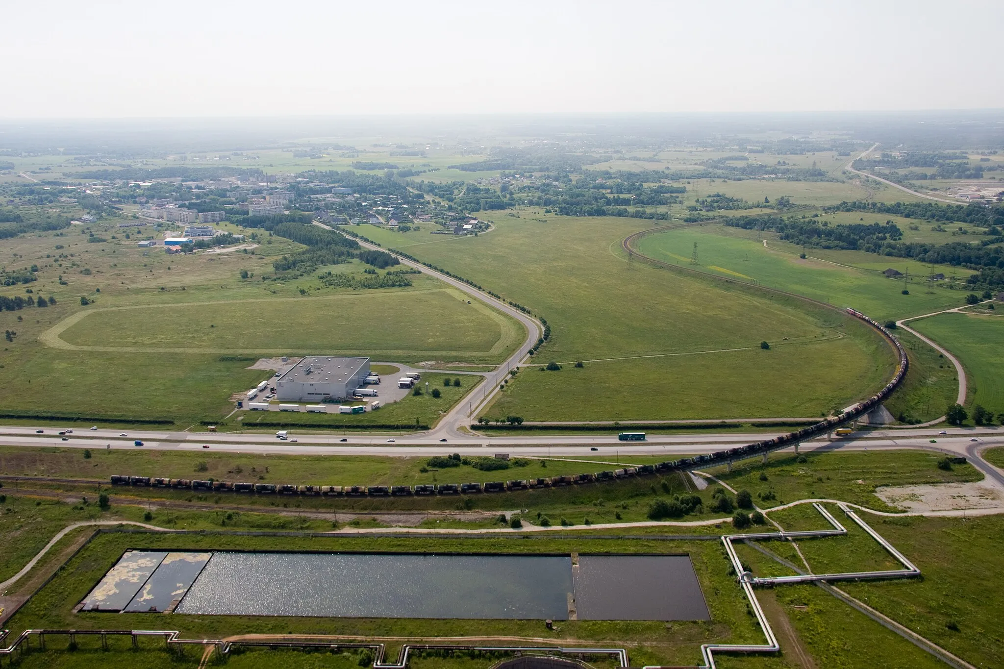 Photo showing: A freight train pulling 60 tank cars heading from Muuga towards Lagedi (near Tallinn, Estonia). Picture taken from top of the chimney of Iru Power Plant (h=202 m)