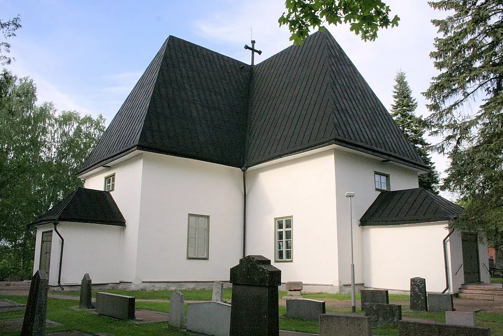 Photo showing: The church of the Evangelic-Lutheran parish in Lapinjarvi, Finland There are two churches side by side in the main village of the municipality of Lapinjarvi. They replaced the two churches which were burned 1742. The church in picture is called the Swedish church as it was ment originally for the Swedish speaking citizens. The church was build 1743–1744, plastered in white 1871 and the stained glasses are made by Lennart Segerstrale. The form of the base of this Swedish church is cross. The form of the base of the Finnish church is retangle and it was built in 1744.