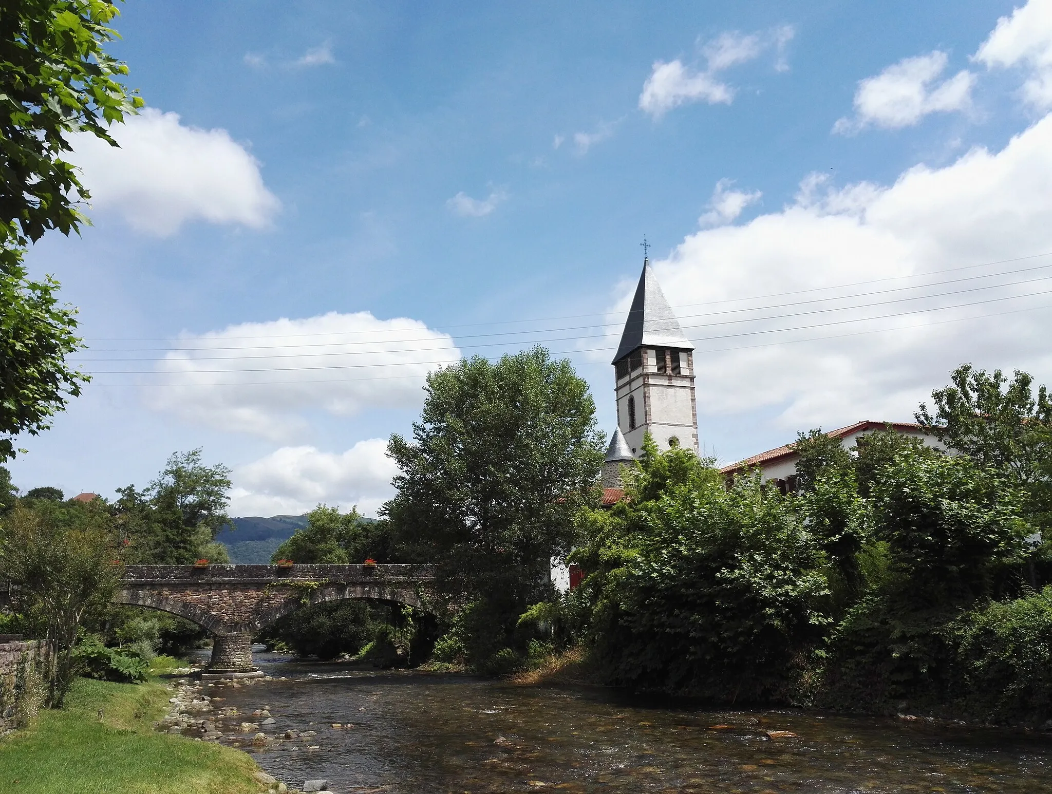 Photo showing: Depuis la rive de la Nive des Aldudes, vu du pont romain de l'église et de l'église St-Étienne.