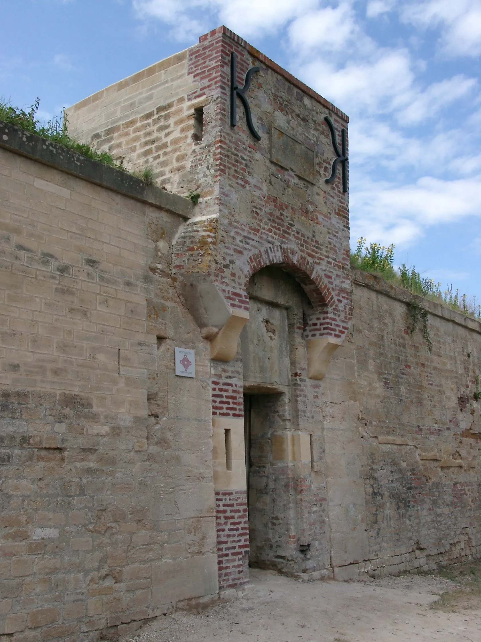 Photo showing: Entrée de la Redoute de Merville dite de Vauban à Merville-Franceville. Cette fortification édifiée selon les plans de Vauban en 1779 fut utilisée par l'armée française puis par les Douanes avant de servir de lieu de garnison et d'observation à l'armée allemande pendant l'occupation allemande dès 1940 du fait de sa situation à l’embouchure de l’ Orne.
La redoute de Merville, propriété du Conservatoire du littoral, et dont la réhabilitation a commencé en 1985, est inscrite à l'inventaire supplémentaire des monuments historiques.