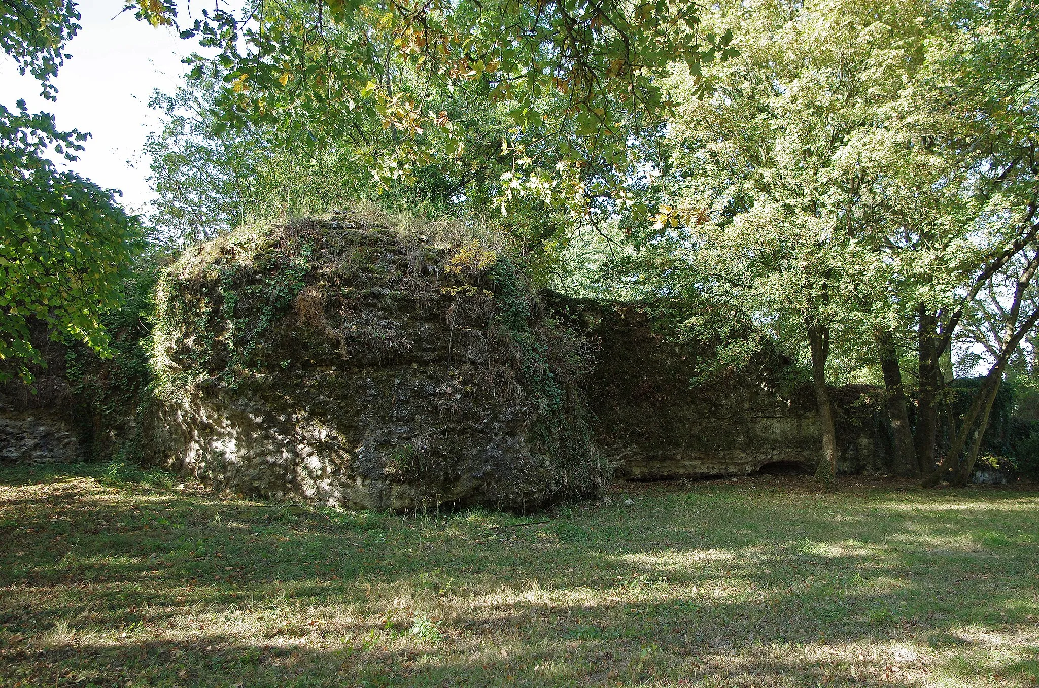 Photo showing: Larçay (Indre-et-Loire).
Le Castellum de Larçay.
Il s'agit d'une fortification militaire gallo-romaine du IIIe siècle, c'est à dire du Bas-Empire.
Le Castellum domine la vallée du Cher et le grand axe de communications de Bourges à Tours*.

Le Castellum est le fortin gallo-romain le mieux conservé de la région et sans doute du Nord de la Gaule. Les murs dont on voit encore les pierres de petit appareil* liées par du mortier, peuvent expliquer en partie cette conservation. Beaucoup d'édifices anciens ont été détruits non seulement par le temps, mais aussi par les populations qui utilisaient ces édifices comme carrières de pierres prètes à l'emploi. Le petit appareil ne pouvant livrer que des moellons de piètre qualité après de gros efforts pour les libérer du mortier, a pu dissuader la récupération donc la destruction de l'édifice.
Les 21 monnaies récoltées à l'intérieur du fortin s'échelonnent entre 120 et 320 après J.C...
Un bâtiment découvert au nord-est du castellum et plusieurs fosses et sépultures à l'intérieur, attestent d'une réutilisation du site de la période mérovingienne jusqu'au XVe siècle.
Le Castellum est un quadrilatère d'environ 80 m sur 70 m. Il est possible qu'il n'y eut jamais de muraille du côté nord, côté vallée.
A proximité, au sud-est du Castellum, se trouvait une grande villa* romaine dont les vestiges ont totalement disparus lors de la construction d'un lotissement dans les années 1970. L'examen de fragments de céramiques récupérés en 1975 confirme une occupation au IIe siècle. Des éléments d'édifices antérieurs, des tronçons de colonnes par exemple,  ont été utilisé à certains endroits dans les fondements du castellum, celui-ci est donc bien postérieur à la villa.

Route de Bourges (Avaricum), capitale des Bituriges, à Tours (Caesarodunum), capitale des Turones, par deux stations intermédiaires (Mansiones), Gièvres/Chabris (Gabris) et Thésée/Pouillé(Tasciaca). "petit appareil", maçonnerie utilisant de petites pierres (8 à 16 cm.) La villa rustica était avec l'ensemble des bâtiments destinée à l'exploitation d'un domaine agricole. www.ville-larcay.fr/larcay/tourisme/le-castellum

fr.wikipedia.org/wiki/Castellum_de_Lar%C3%A7ay