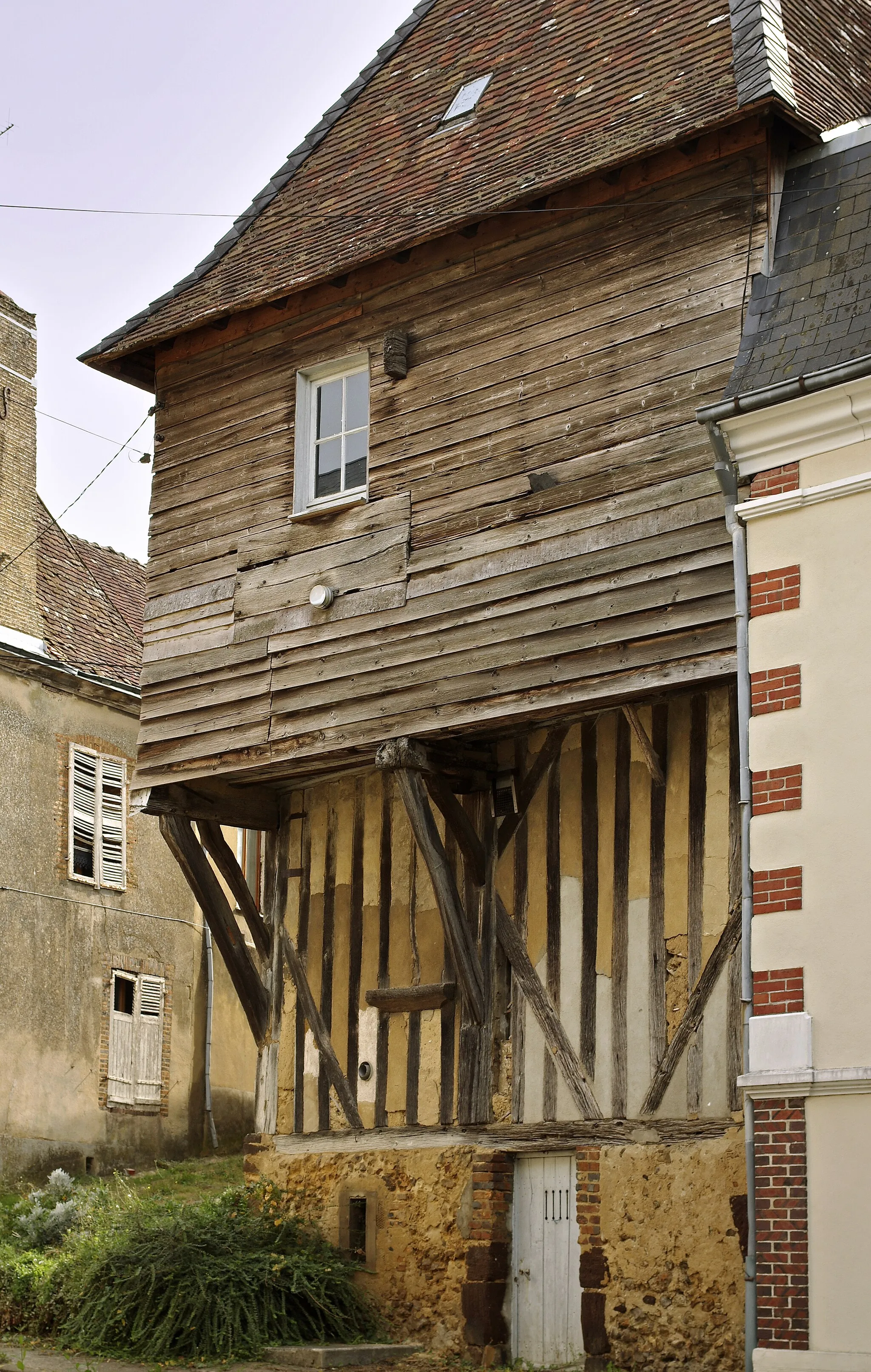 Photo showing: Mondoubleau (Loir-et-Cher)

La maison du Gouverneur (XVe siècle).
Cette belle maison aurait été offerte par les comtes de Vendôme, vers 1460, au gouverneur du château Jean de Courcillon pour le remercier de sa belle défense de la forteresse contre les anglais.
Durant les XIe et XIIe siècles, Mondoubleau était sous la coupe des rois d'Angleterre. En 1406, la baronnie est vendue aux Bourbons, comtes de Vendôme.  
Au XVe siècle le château soutint deux sièges du parti anglais, alors que Jean de Courcillon en était gouverneur et logeait dans une maison devant le pont-levis qui porte encore son nom. (Essai historique et statistique sur le canton et la ville de Mondoubleau, paru en 1837).

Sous le règne du roi Louis XI, le châtelain de Mondoubleau, Jean de Courcillon, ancien procureur de La Ferté-Bernard, est chargé de la direction du procès de Renée de Vendômois accusée de meurtre sur son mari :

Dans les premières années du règne de Louis XI, Souday avait pour seigneur Jean de Saint-Berthevin. Vers 1468, il épousa une noble dame, Jeanne de Tucé veuve de Guillaume de Chaources. Jeanne de Tucé mourut dès 1474. "Son mari avait beaucoup de piété et de religion, remarque un brave curé de la paroisse, mais par malheur pour lui, il ne put garder la continence et crut qu'il valait mieux convoler en secondes noces que de brûler". Il y avait alors à la Tibonnelière une jeune et belle veuve nommée Renée de Vendômois. Jean de Saint-Berthevin à 40 ans passé épousa, en secondes noces, Renée âgée de 16 ans seulement,  vers 1478. Le mari installa Renée au logis seigneurial où la vie s'écoulait entre le fils qu'elle eut de Jean, les deux enfants de la première épouse de son mari, les chasses de celui-ci, et les réceptions de toute la noblesse des environs. Parmi les visiteurs assidus, il y avait Guillaume du Plessis, jeune et bien fait et qui se prétendait cousin de Renée. 
"Hélas Guillaume du Plessis, bien que gentilhomme de nom et d'armes, n'était qu'un paillard sans vergogne il entraîna Renée vers l'abîme et la chute de celle-ci fut complète". 
La malheureuse en arriva à subir toutes les volontés de son séducteur, au point qu'elle déroba à son mari des sommes considérables pour payer les bonnes grâces de Guillaume. 
La disparition des écus d'or alerta le mari : "Renée et et moi, pensa-t-il, avons seuls la clef du coffre. Ce n'est pas moi qui gaspille mon trésor, donc c'est elle!" 
Jean qui soupçonnait déjà la liaison de Renée avec Guillaume, fit venir sa femme : "Il n'est plus besoin de dissimuler. Vous avez apporté la honte sous mon toit. Vous me trahissez avec ce larron d'honneur, Guillaume du Plessis, à qui vous devez encore payer ses honteuses complaisances. Êtes-vous tombée assez bas, misérable gouge!". Le seigneur de Souday avisa un fagot auprès de la cheminée. Il en tira une solide verge et en frappa Renée à plusieurs reprises. 
Renée protesta de son innocence et n'avoua qu'avoir, par complaisance, prêté de l'argent à Guillaume qui en avait besoin. Saint-Berthevin l'admit mais mena la vie dure à sa femme. 
Renée pria alors Guillaume de rembourser, ce à quoi celui-ci répondait par des menaces envers Saint-Berthevin. 
Le couple illégitime résolut alors de supprimer l'obstacle. Le poison fut essayé sans succès. On décida de sous-traiter le problème : "Un ancien serviteur de Guillaume du Plessis, répondant au nom de Grand-Jehan, parut avoir les qualités requises pour retrancher Saint-Berthevin du nombre des vivants." Le valet épousa la cause, moyennant une bonne récompense. 
Dans le temps de Noël 1483, Grand-Jehan déguisé en mendiant aborda le seigneur de Souday sortant de la messe, un peu avant le moulin de Taillefer : " Mon bon seigneur, faites-moi l'aumône, pour l'amour de Dieu!". Saint-Berthevin ne fut pas étonné de la rencontre, les mendiants n'étaient pas rares, il mit la main à l'escarcelle pour en tirer quelques pièces. "Grand-Jehan rejeta rapidement son manteau sur son épaule et d'une main sûre armée d'un long couteau il frappa sa victime par le côté. Celle-ci poussa un grand cri et tomba lourdement". Renée de Vendômois était veuve.
Renée assista aux funérailles de son mari en habits de veuve, Grand-Jehan avait disparu. 
La rumeur publique désigna Guillaume du Plessis comme l'auteur du crime. Par peur celui-ci s'enfuit à Saint-Malo, ville franche, abandonnant Renée. 
Pour bénéficier de l'immunité d'une ville franche, il fallait d'abord confesser par écrit son crime avec les plus menus détails, la moindre omission conduisant au gibet. Guillaume avoua tout pour éviter la pendaison, dont sa complicité avec Renée. Les enfants du défunt seigneur de Souday firent donc intervenir la justice.  
L'information conduite par les officiers de Mondoubleau amena l'arrestation de Renée de Vendômois. 
Le châtelain de Mondoubleau, pour le comte de Vendôme était alors Jean de Courcillon, ancien procureur de La Ferté Bernard. Chargé de l'administration des biens du défunt seigneur de Souday, il détourna pour lui et au profit de la prisonnière des sommes importantes, et ayant la direction du procès, il favorisa scandaleusement la coupable, au point qu'il fut accusé d'avoir entretenu avec elle des relations criminelles.   
Jean de Courcillon fut appréhendé et conduit dans les prisons de la conciergerie à Paris. Pour sa défense, il prétendit que le coffre au trésor de Jean de Saint-Berthevin qu'il avait en garde lui avait été soustrait dans sa maison de la Ferté-Saint-Bernard par le seigneur du lieu. Le 4 septembre 1486, le Parlement ordonne son élargissement jusqu'au 1er décembre. Le fils de Jean de Courcillon, Louis de Courcillon succédera à son père comme châtelain de Mondoubleau. 
De son côté, Guillaume du Plessis fit jouer ses relations à la cour pour obtenir son absolution. Le jeune roi Charles VIII, trompé par une présentation fantaisiste des circonstances de la mort du seigneur de Souday, accorda à Guillaume des lettres de rémission datées du Vendredi Saint 1484. Guillaume épousa, la même année, Catherine de Ray, et entrait ainsi dans une des meilleures familles bourguignonnes. 
Après une année d'enquêtes et autres procédures, la cause de Renée de Vendômois vint au Parlement de Paris, sur demande des enfants de la victime, Jean de Saint-Berthevin. Renée changea donc de prison et passa de Mondoubleau à Paris. Elle arriva à Paris au début 1485. La cour ordonna le 29 janvier 1485, que Renée serait logée dans la maison de Jean Bachelier, huissier au Parlement :  « la dite damoiselle (Renée) sera mise en garde en la maison de Jehan Bachelier, huissier en la dite court, laquelle maison elle promectra tenir pour bonne et loyale prison... et au dit huissier sera enjoinct de tellement seurement garder la dite damoiselle que aucun inconvénient n'en adviengne ». Les frais de procédure et de nourriture étaient, selon la coutume, supportés par l'accusée.  Le 2 mai, Renée de Vendômois fut envoyée devant le Prévôt de Paris qui n'était autre que le petit-fils d'Ambroise de Loré, noble messire Jacques d'Estouteville chevalier, seigneur de Beyne, baron d'Ivry et de Saint-Andry-en-la Marche, conseiller et chambellan du roi. Il « n'avoit aucun degrez d'estude », la science du droit n'était point encore nécessaire pour remplir les charges de judicature. 
Renée ne confessait pas facilement son crime, on résolut donc de la soumettre à la question (la torture). 
"Elle fut mise plusieurs fois à la torture, probablement aux brodequins. Pendant que les coins de bois, frappés par le maillet du questionnaire, lui meurtrissaient les jambes et faisaient craquer ses os au milieu de souffrances inouïes, un impassible greffier se tenait à son bureau, prêt à enregistrer des phrases faites de cris de douleur et d'aveux." Renée en resta infirme et impotente.  
La veuve de Jean de Saint-Berthevin s'entendit condamner " à estre traynée et arse au marché aux pourceaux de Paris." L'arrêt portait aussi confiscation de ses biens, le roi et les juges pouvaient donc se partager ses biens, au détriment de son jeune fils.
www.mairie-mondoubleau.com/tourisme-loisir/histoire-local...
fr.wikipedia.org/wiki/Mondoubleau

Voir : LA RECLUSE RENÉE DE VENDOMOIS (A. Ledru) - Revue historique et archéologique du Maine - Tome 31 - Année 1892.