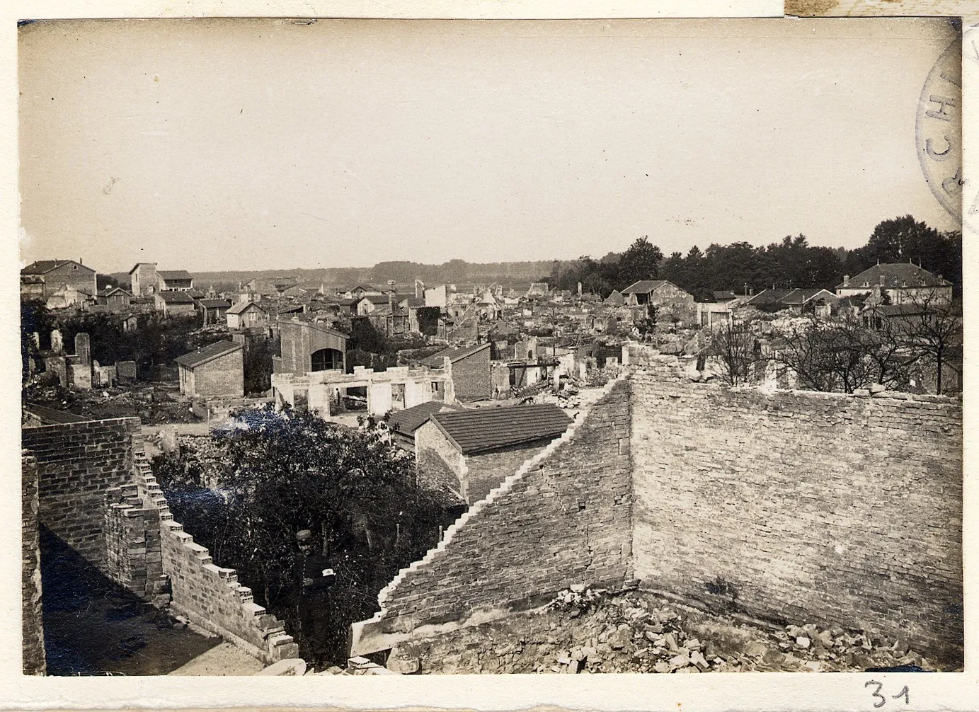 Photo showing: Vue générale des ruines de Semaize-les-Bains (Marne) suite au bombardement de la ville.
1915.
Guerre 1914-1918.

Un soldat infirmier pose au milieu des gravats.