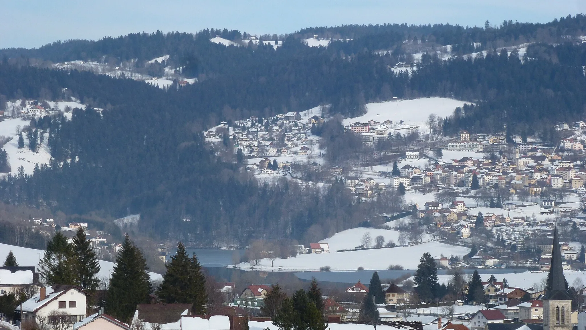 Photo showing: Paysage hivernal à Villers-le-Lac. L'église Saint-Jean (XIXe siècle), le Lac de Chaillexon (partiellement recouvert de glace) et Les Brenets (Suisse).