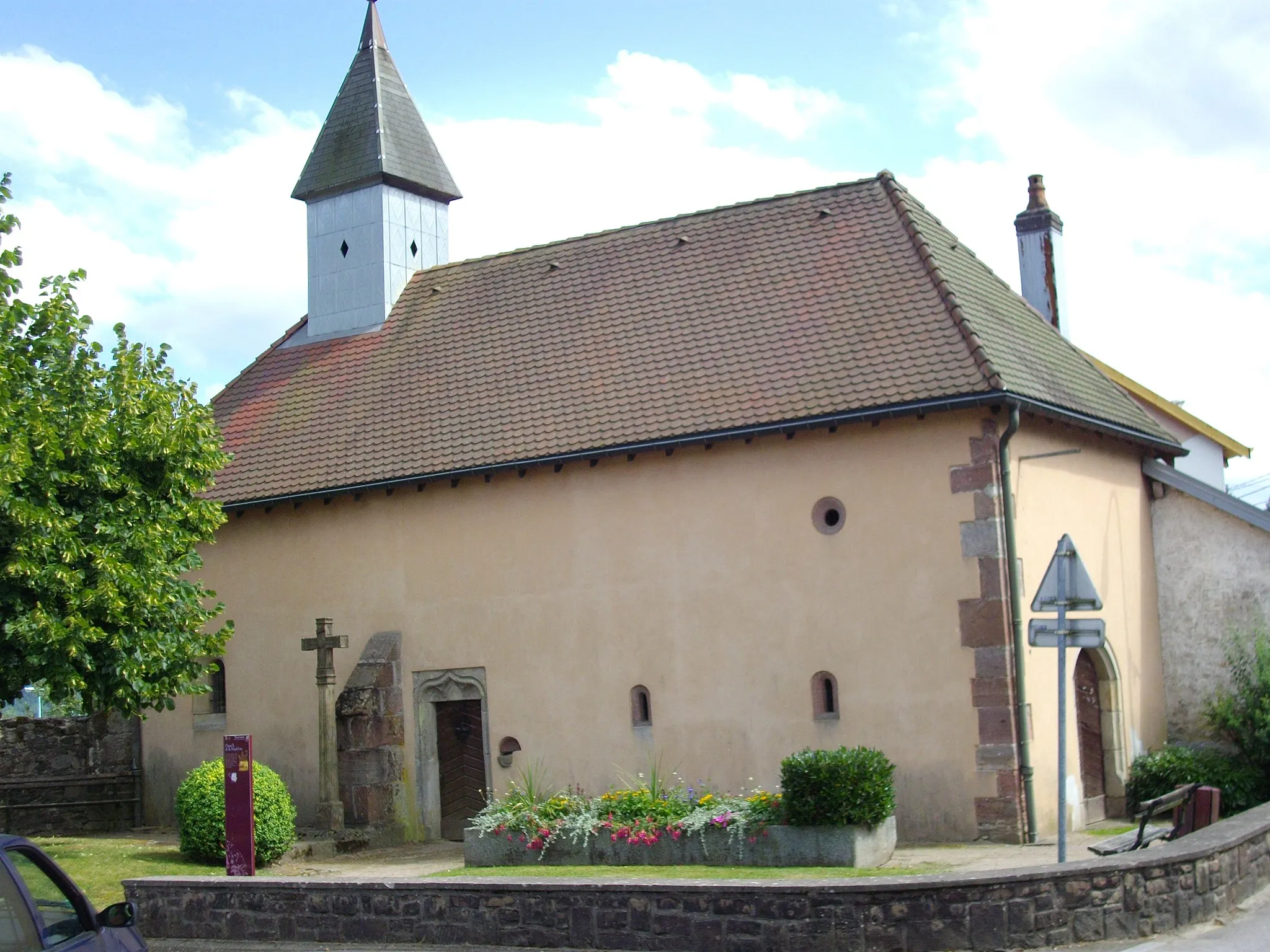 Photo showing: La peste, dont nous conservons l'histoire à travers la léproserie de « La Madeleine » à la sortie de la ville de Remiremont, à droite de la route qui conduit vers Bussang et Mulhouse.
Ancienne chapelle de léproserie des 17e-18e siècles, inscrite sur l’inventaire supplémentaire des Monuments historiques le 16 juillet 1991, et en qualité de site inscrit le 24 janvier 1944. Cet édifice est le seul qui reste des bâtiments de cette ancienne léproserie créée lors de la seconde épidémie de lèpre en Lorraine. Le sol de la nef comporte plusieurs pierres tombales.