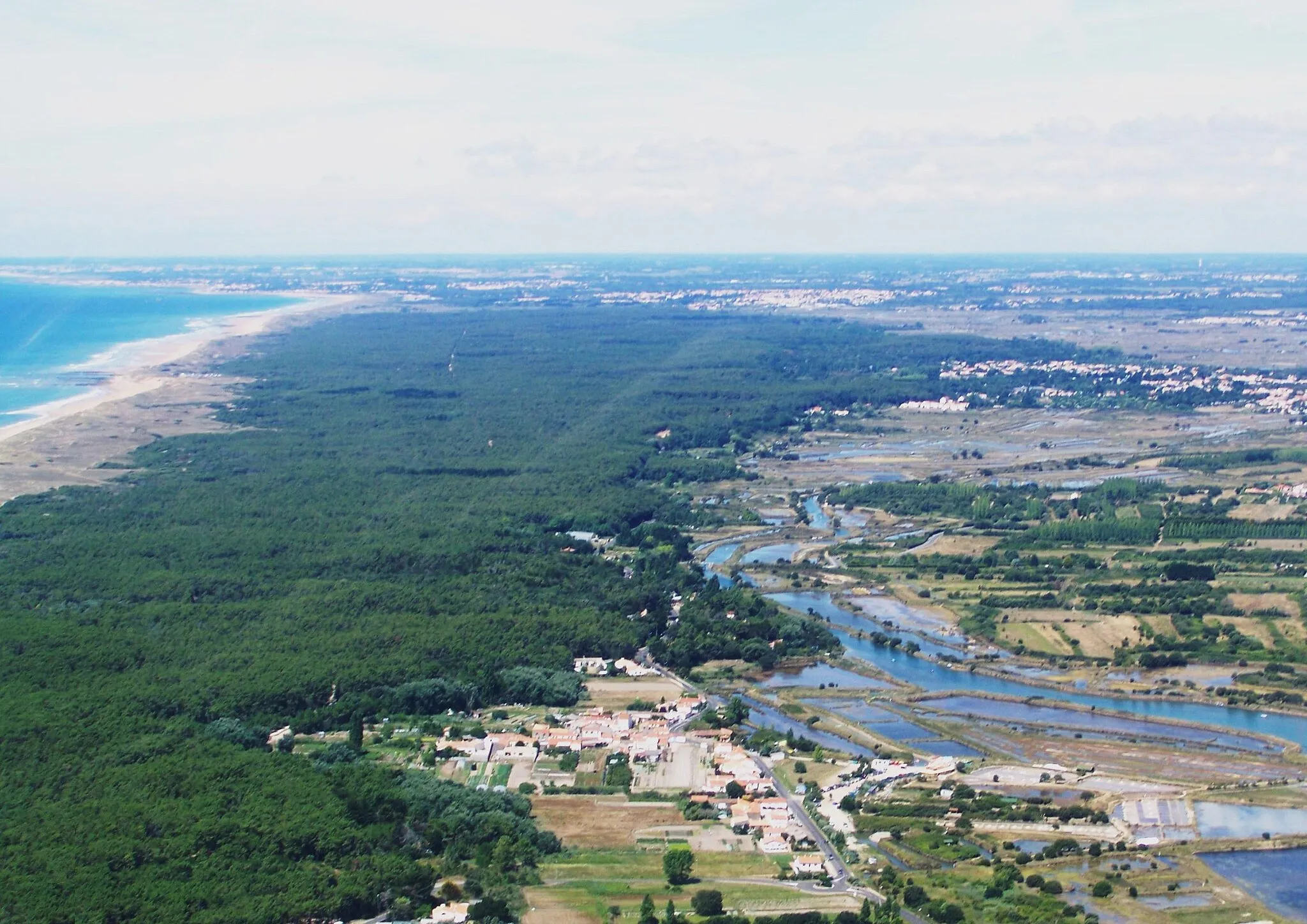 Photo showing: Sight from the air on French commune of Olonne-sur-Mer in Vendée. Can here be seen the city center, feeder canal and saline water on the right, and the domanial forest of Olonne and the Atlantic ocean on the left.