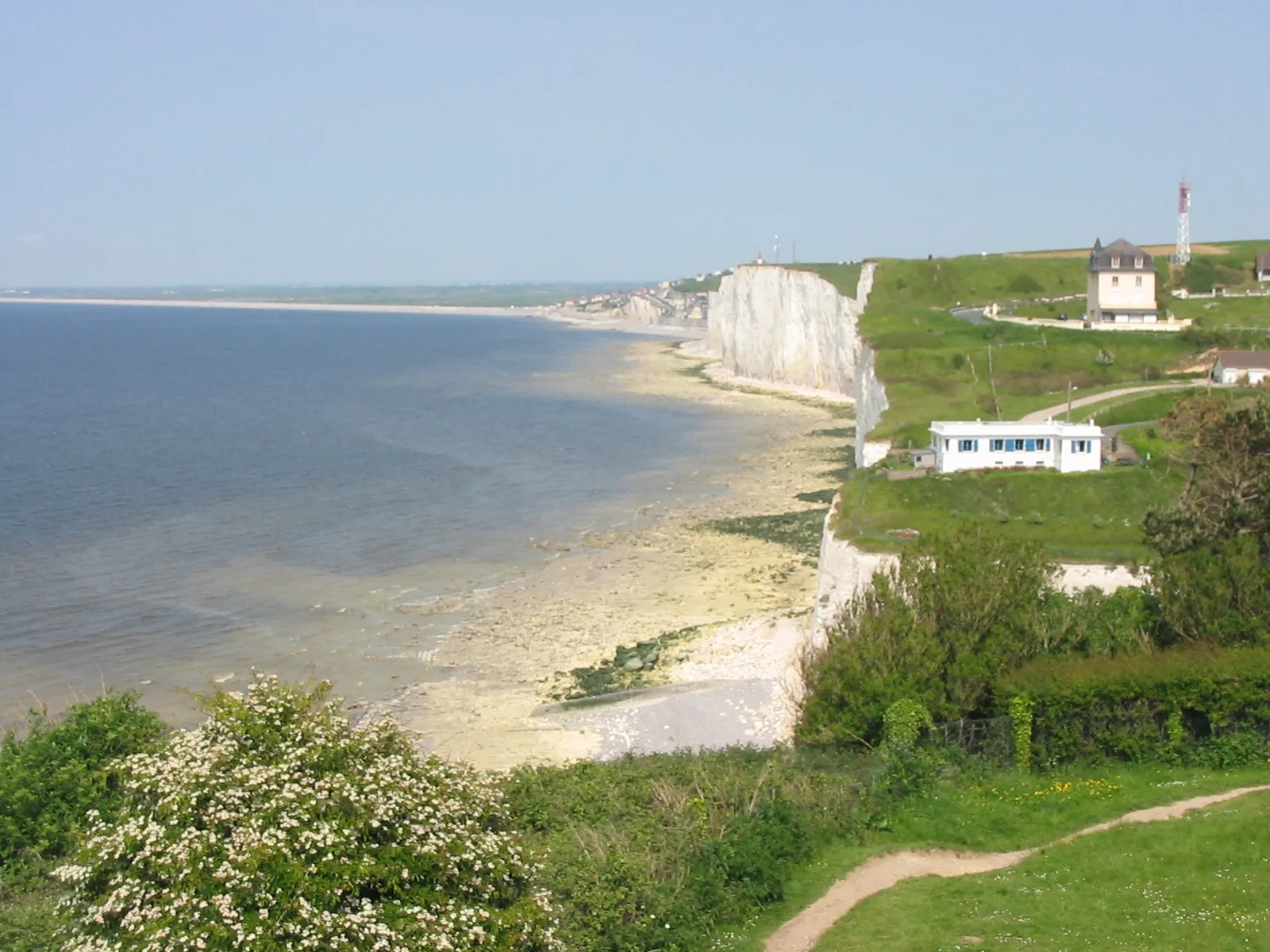 Photo showing: Le Bois de Cise et une vue des falaises picardes. Au premier plan et en contrebas de la maison blanche, le Bois de Cise et son accès à la mer. Au second plan, une vue de la commune de Ault (Somme), à laquelle le bois est rattaché sur le plan administratif. On aperçoit ensuite le bourg d'Onival et tout au fond, le cordon littoral qui forme le hâble d'Ault.