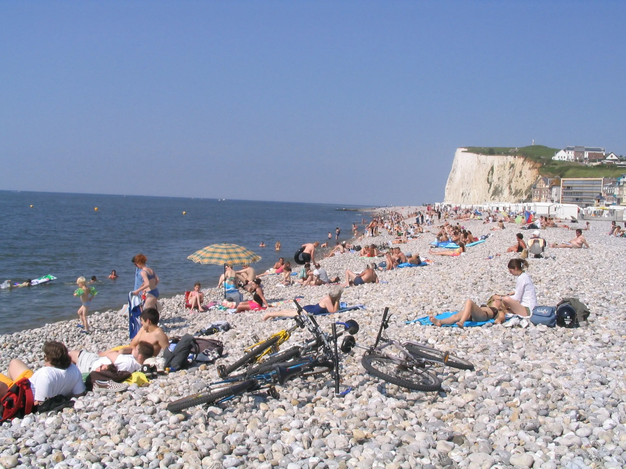 Photo showing: La plage de Mers-les-Bains à marée haute. Les touristes attendent sur les galets que la mer descende à nouveau.