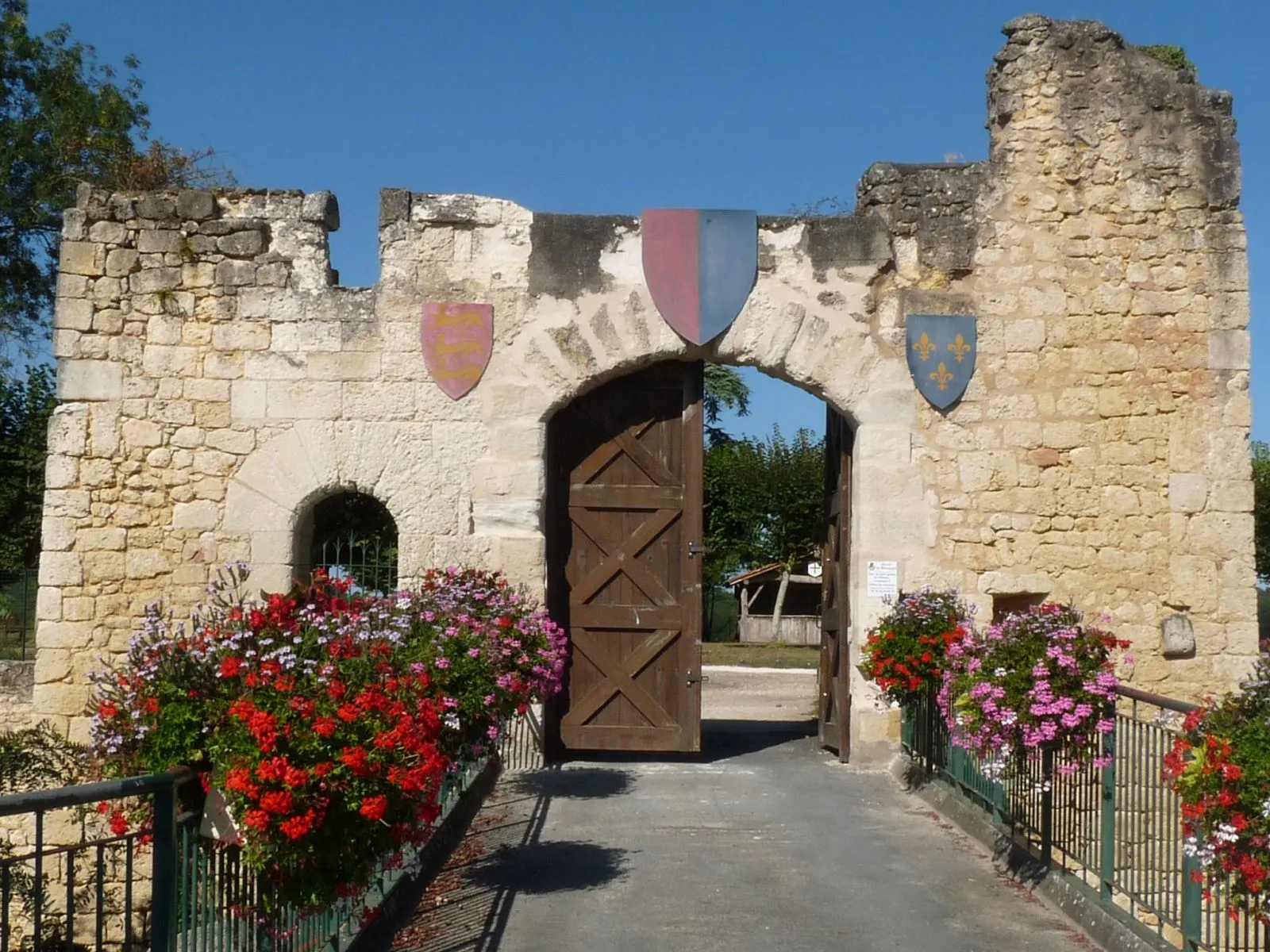 Photo showing: entrance of the castle of Montguyon, Charente-Maritime, SW France; english (red) and french (blue) flags