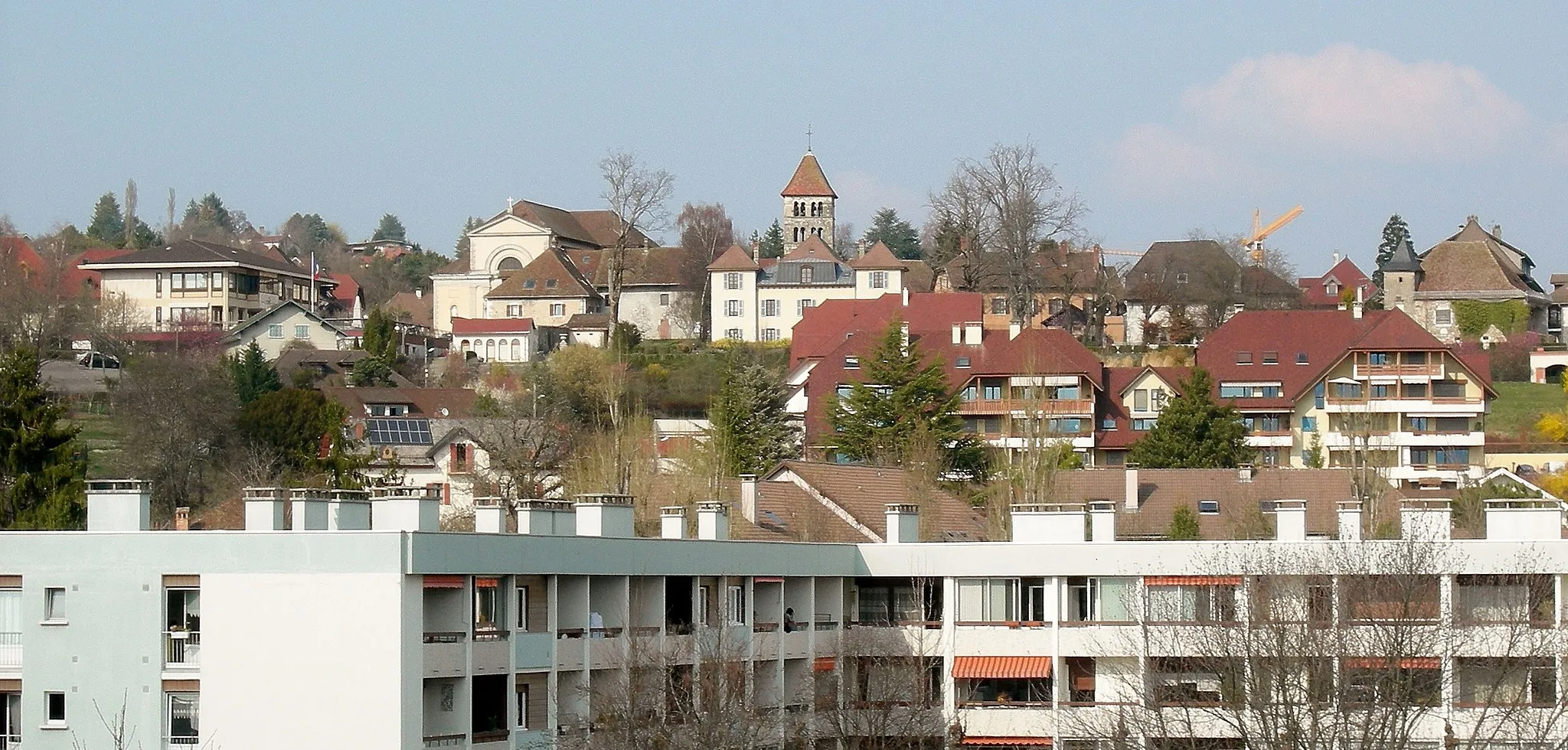 Photo showing: On the top of the hill, the principal place of en:Annecy-le-Vieux (en:Haute-Savoie, en:France) overlooks the Clarines'neighborhood. From left to right :
- On the far left, Annecy-le-Vieux City hall
- Church of Saint-Laurent
- Annecy-le-Vieux's bell tower (romanesque art)
- Below the bell tower, the house where en:Gabriel Fauré lived in
- On the far right, La Pesse Castle.
