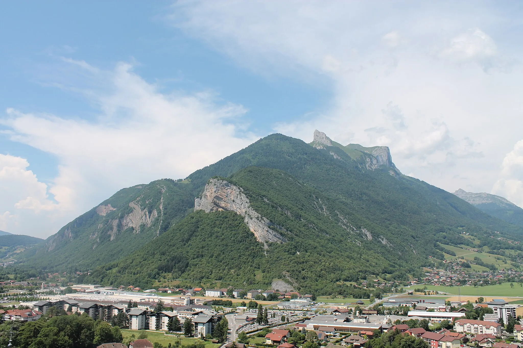 Photo showing: Au premier plan la zone industrielle de Viuz. Au second, le Rocher de Viuz, dans l'axe le sommet l'Arpettaz, enfin en arrière-plan, la pointe de Chauriande (à gauche, 1803 m) et l'Arclozan (à droite). Entre les deux se trouve le crêt des mouches (2 033 m).