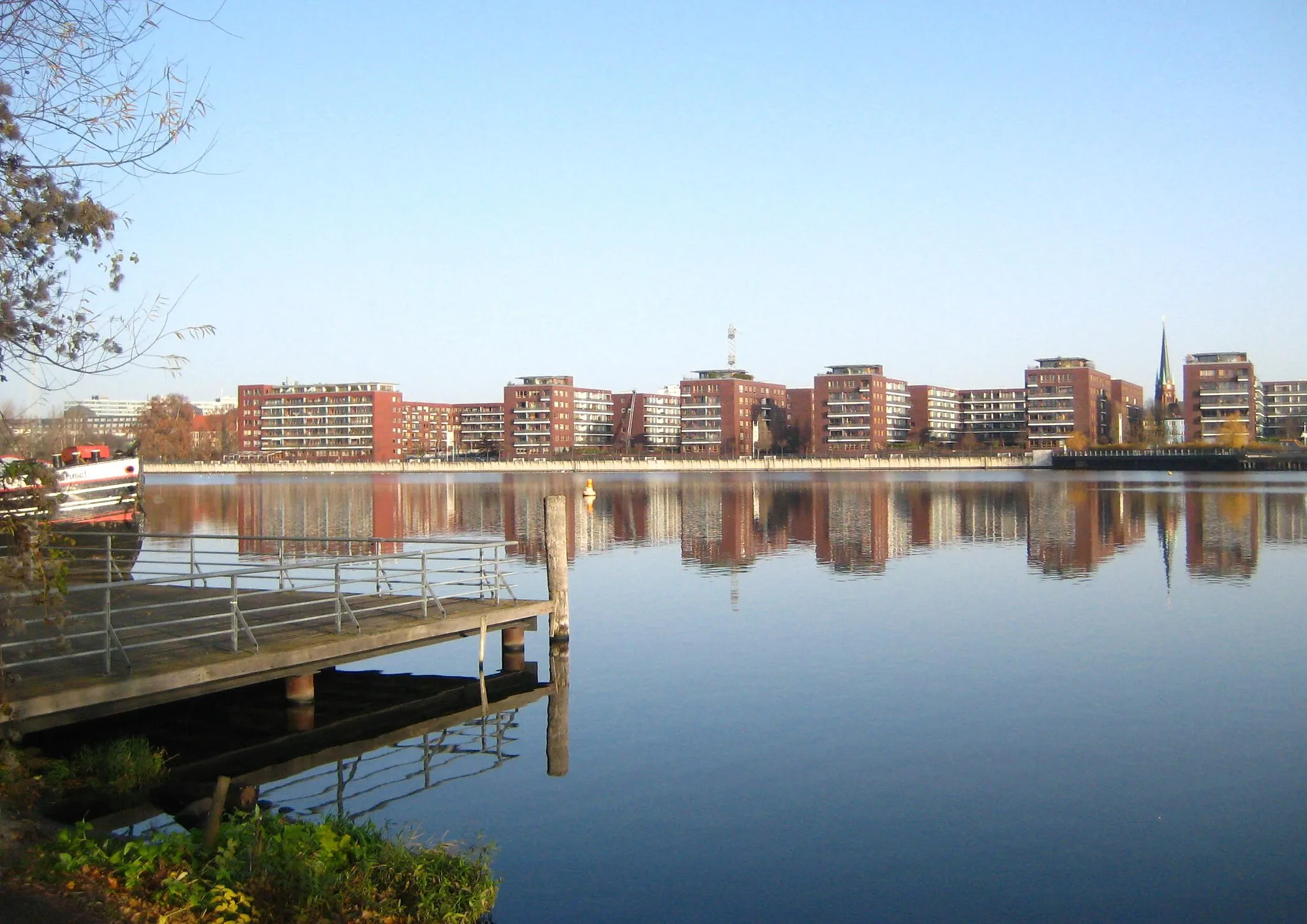 Photo showing: A view over the Rummelsburg Lake in Berlin from the Stralau peninsula in the borough of Friedrichshain to the residential complex Hauptstraße in the borough of Rummelsburg. The buildings were construct in 1997/1998.