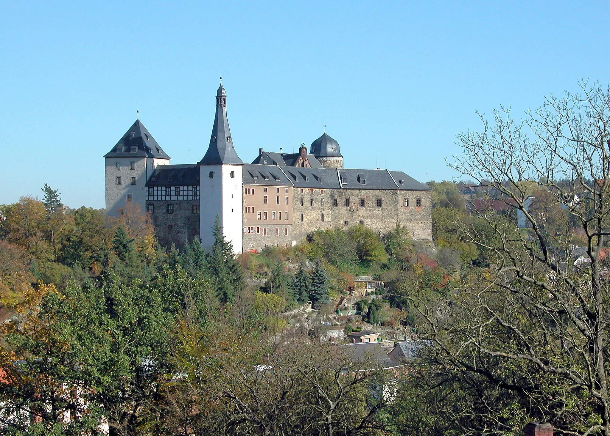 Photo showing: 15.10.2007  08499  Mylau, Burg 1: Burg (GMP: 50.618285,12.265690). Die Burg Mylau ist die größte Burg des Vogtlandes. Der in Mylau beschworene Kaisermythos gründet sich auf Kaiser Karl IV. (1316-1378), der die Burg 1367 erwarb und im gleichen Jahr besuchte. Die Burg indes ist älter und entstand schon um 1180. 1460 verkaufte Kurfürst Friedrich der Sanftmütige von Sachsen (1412-1464) das Schloß Mylau an die Metzsch, welche den Besitz bereits seit Ende des 14. Jahrhunderts als Amtleute verwaltet hatten. Unter ihnen vollzog sich der  Übergang zum Wohnschloß. Nach mehreren Eigentümerwechseln übernahm 1792 Johann Friedrich Golle den Besitz. Ihn interessierte vor allem das zur Burg gehörende Vorwerk in Obermylau. Die Burg verfiel. Zwischen 1808 und 1828 betrieb der Mylauer Textilunternehmer Christian Gotthelf Brückner in den Burggebäuden eine große Baumwoll-spinnerei. Der alte Glanz lebte auf, als die Stadt Mylau 1892 das Rittergut Mylau und damit auch die Burg kaufte. Die Instandsetzung der "Kaiserburg", die bis 1909 andauerte, war mit einem historisierenden Um- und Neubau der Burggebäude verbunden. Neben dem Bergfried wurde 1894 bis 1896 anstelle des Palas der mittelalterlichen Burg das Rathaus der Stadt 
Mylau errichtet. Heute wird die Burg als Museum genutzt. Sicht von Westen                                                                                            [DSCN30670.TIF]20071015260DR.JPG(c)Blobelt