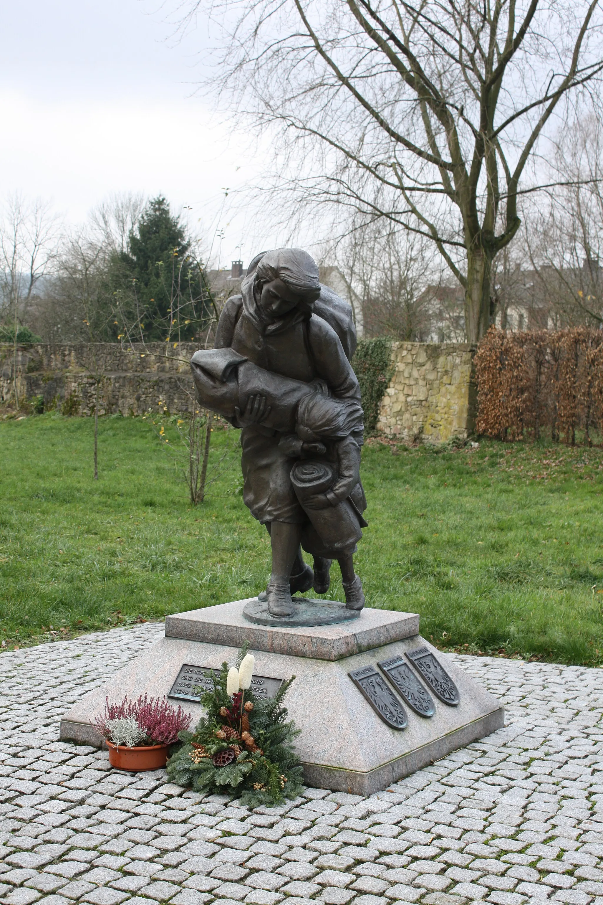 Photo showing: Memorial in front of Burg Horn: Mother with two children on the flight. To remember people on flight and driven out of their home countries: Pommerania, Silesia, East Prussia etc. at the end of World war II. Reminder for a unified Europe.