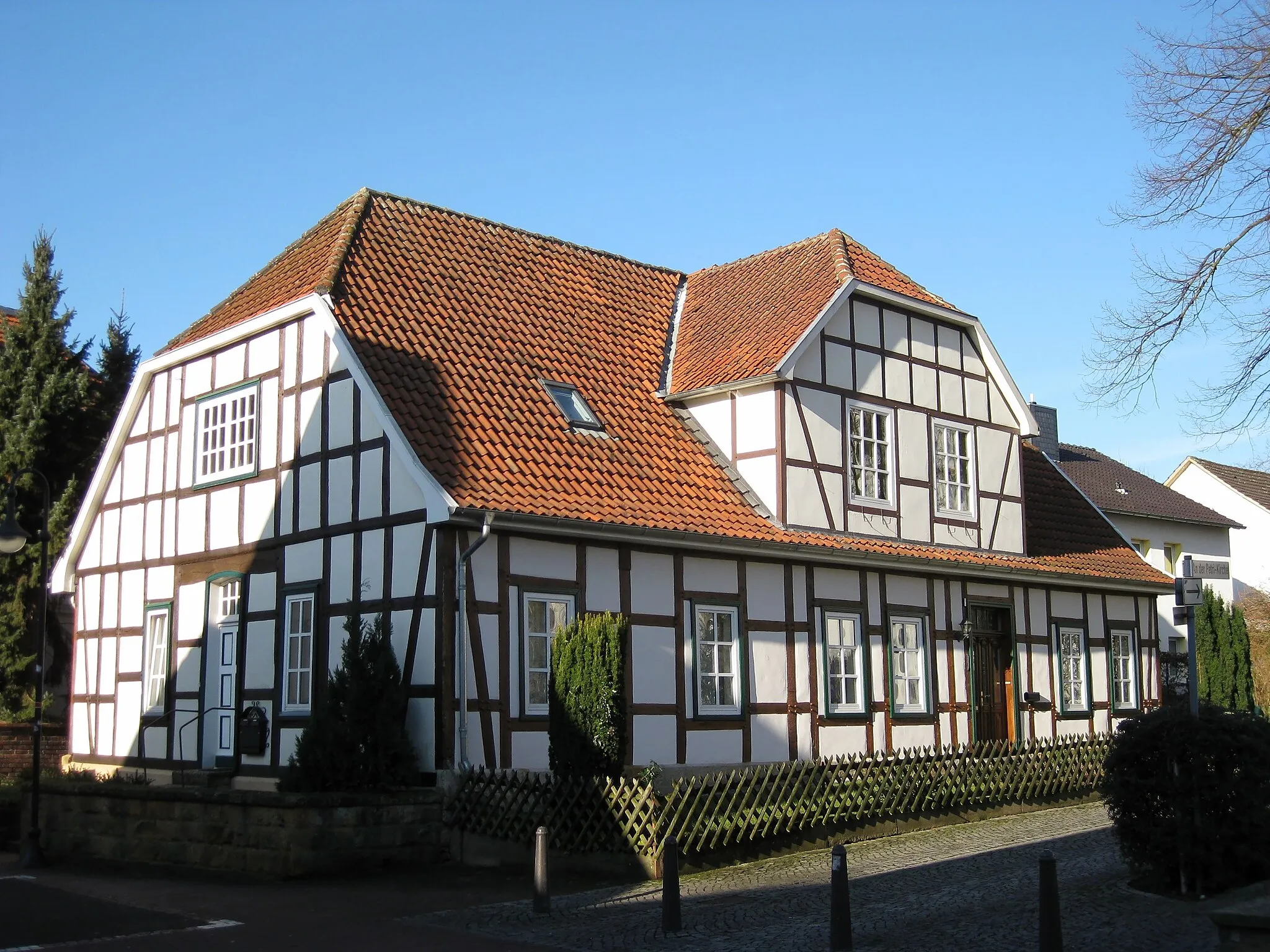 Photo showing: Former house of the choirmaster in Versmold, text on infoboard: The original choirmaster's house of the parish was destroyed in the town fire in 1804. The current buiding was erected as its replacement between 1806 and 1808. Gottfried Möllenstedt, later rector of the University of Tübingen, was born here in 1912.