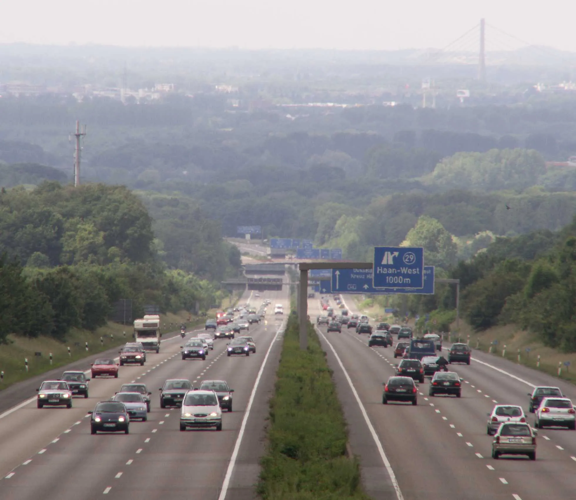 Photo showing: Blick nach Westen auf die A46 zwischen Haan/Ost und Haan/Hochdahl am Abstieg vom Niederbergischen Land in die niederrheinische Tiefebene. Im Hintergrund rechts die Fleher Brücke über den Rhein.