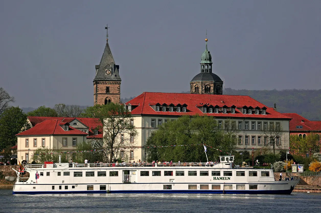 Photo showing: Das Schiff "Hameln" der Flotte Weser am Schiffsanleger in Hameln vor dem Hotel "Stadt Hameln" und der Münsterkirche.