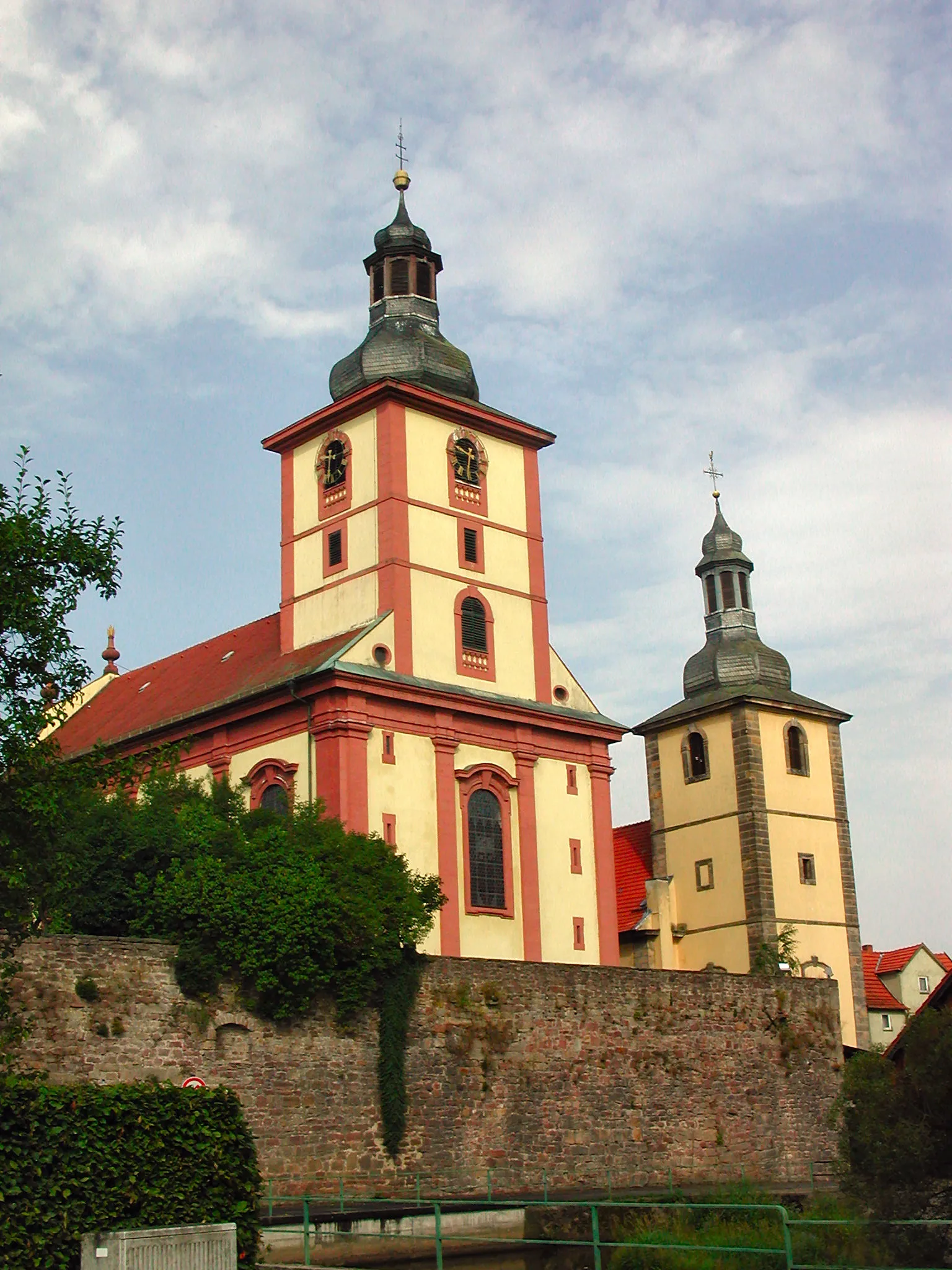 Photo showing: Kirchspiel zu Burghaun. Rechts ist die jüngere evangelische Kirche, links die auf der Ruine des alten Stadtschlosses erbaute ältere katholische Kirche zu sehen.