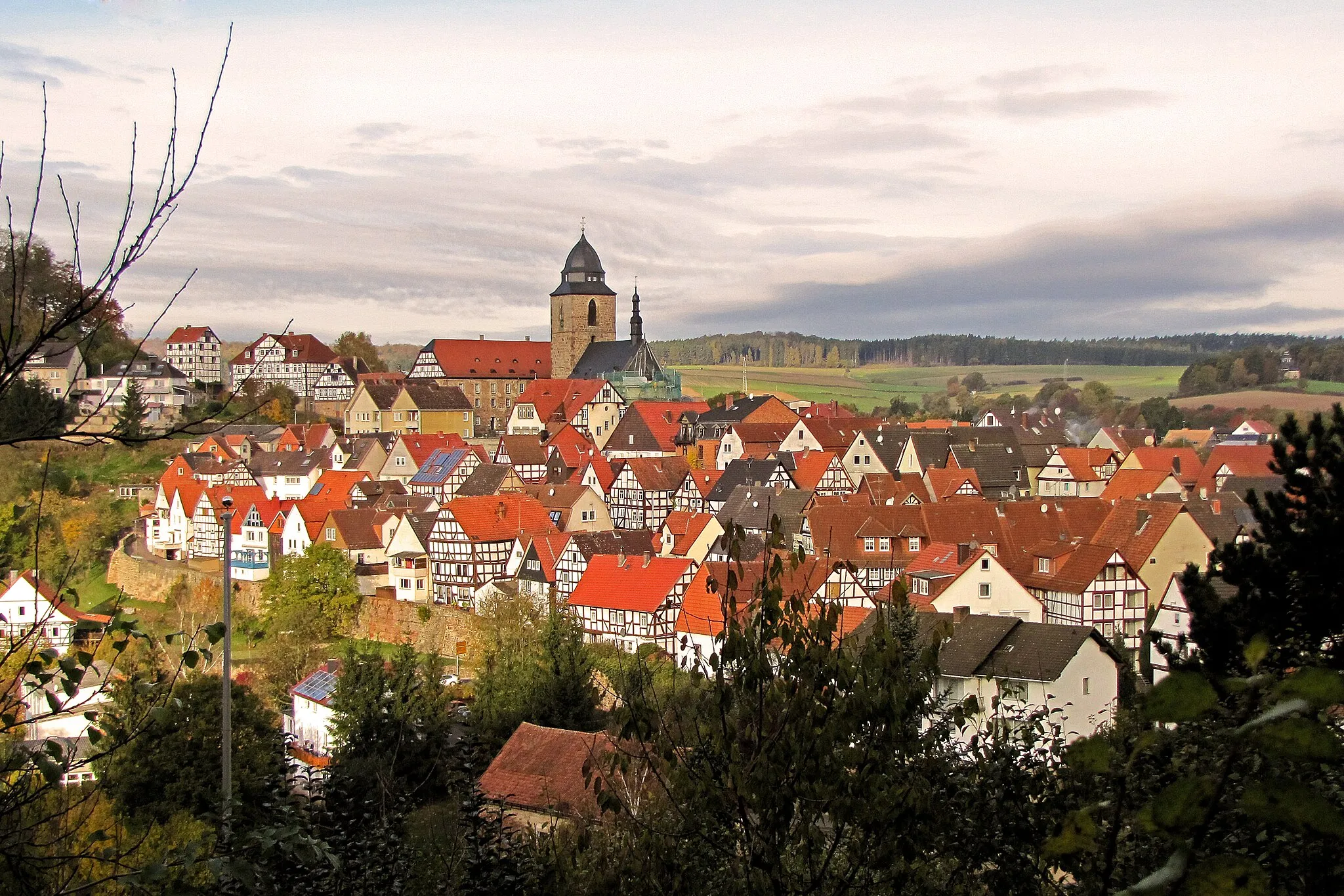 Photo showing: Westward view of the historic inner city of Naumburg (Hesse). In the centre of the picture is the Catholic city parish church St. Crescentius.