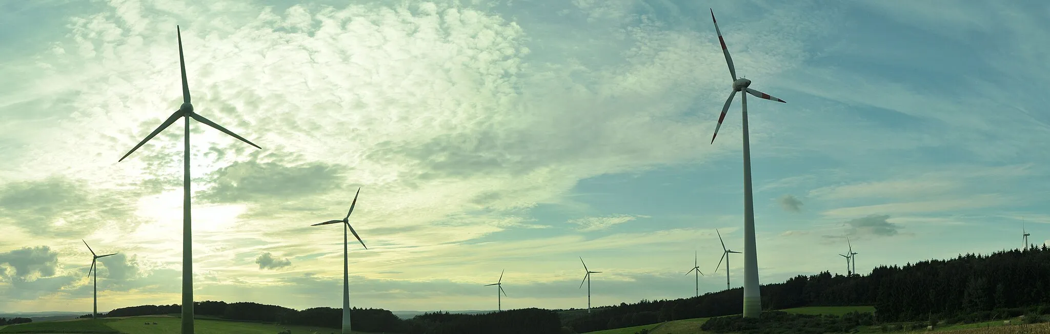 Photo showing: The entire wind farm near Gebhardshain and Fensdorf. Seven Nordex N90, in the right side of the image more in the background, two Enercon E66, the two in the middle with the red-white rotor-blades and the new wind turbines in the left side - two Enercon E53.