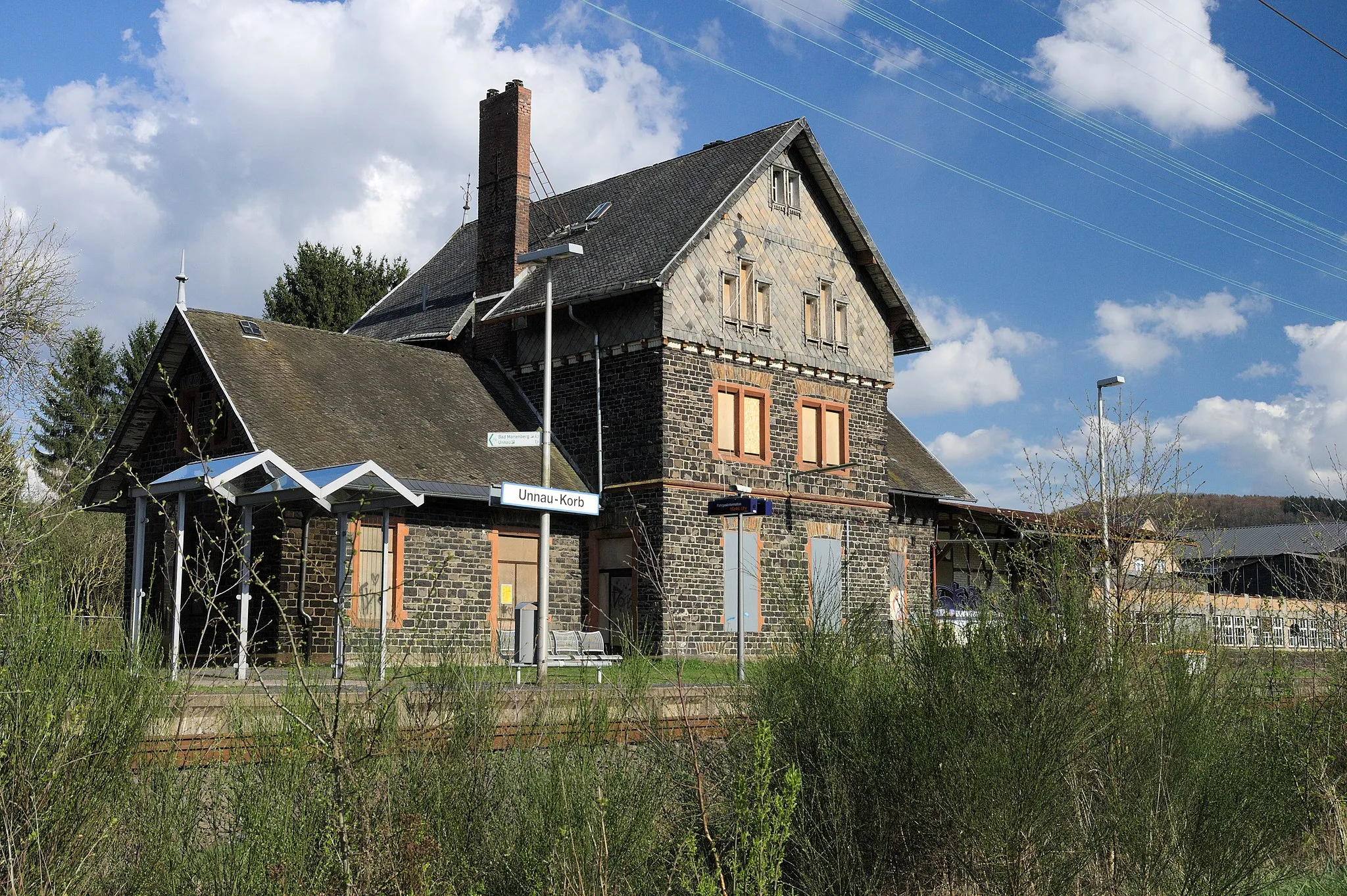 Photo showing: Former railway station (now only train stop) at the Oberwesterwaldbahn (Altenkirchen-Limburg (Lahn)). Cultural heritage monument. Location: Bahnhofstraße 10, Unnau-Korb, Westerwald, Germany. Erected about 1885.