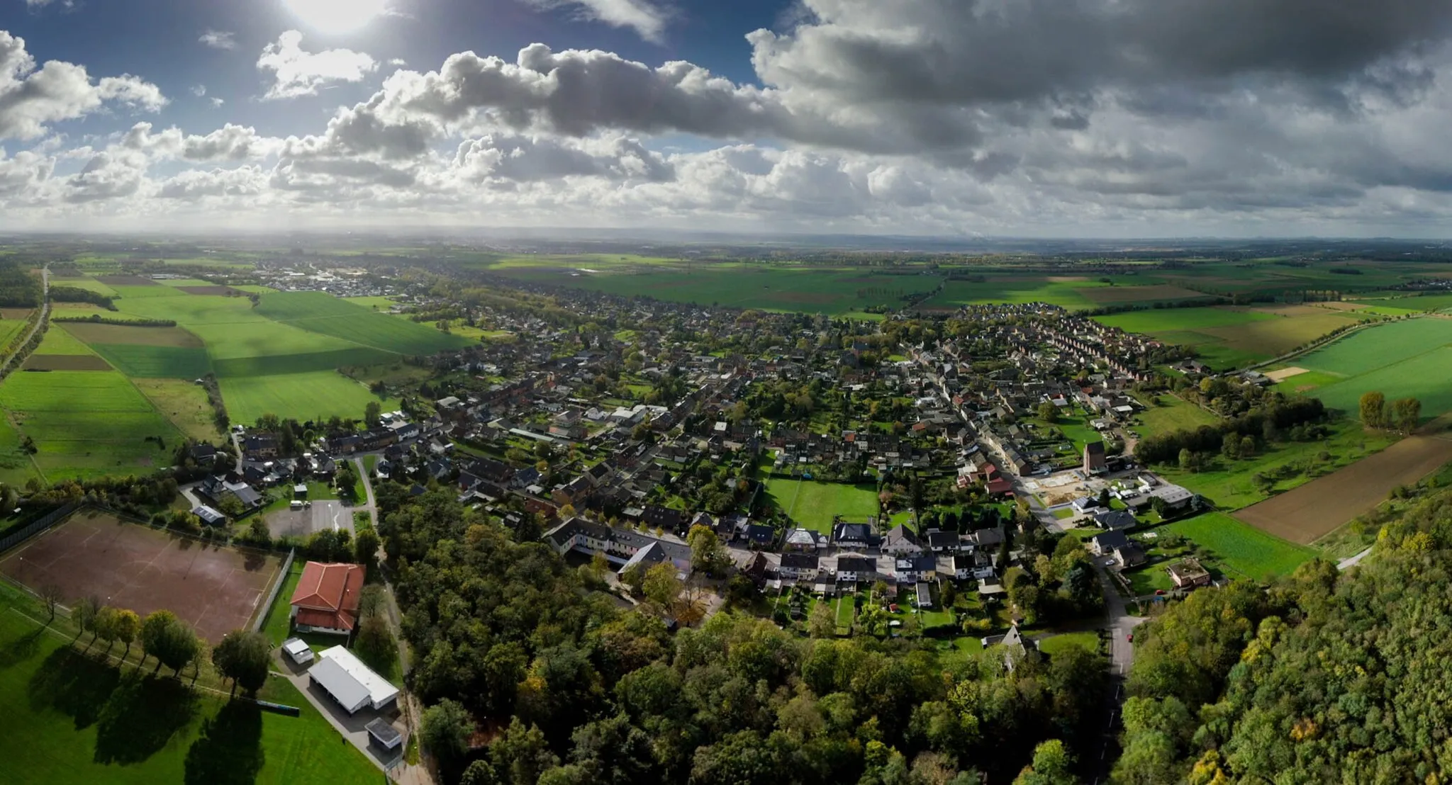 Photo showing: Die Gemeinden Nieder- und Oberzier (links) liegen unmittelbar am Braukohletagebaugebiet von Hambach. Die Dörfer nordöstlich von Niederzier fielen dem riesigen Kohleabbaugebiet zum Opfer. Ganz links im Bild ist die Ortschaft Ellen zu sehen. Aufgenommen mit einer Fotodrohne.